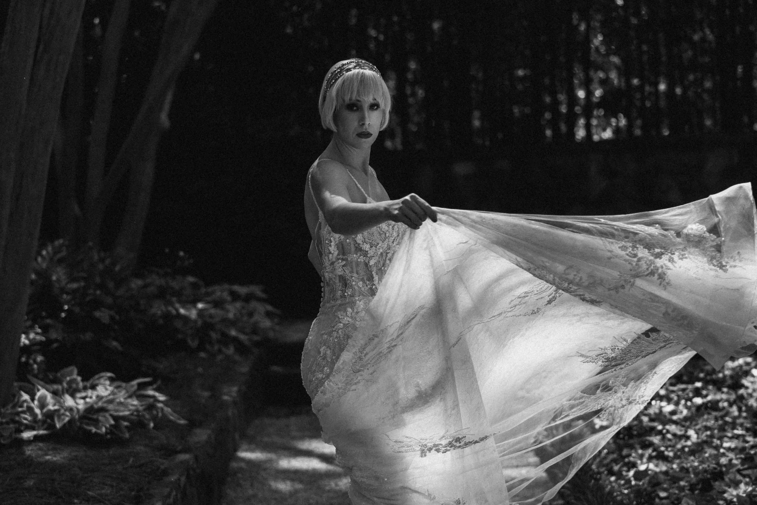 Bride in a flowing gown turning gracefully through dappled forest light — captured by Tirtha Uluwatu Wedding Photographer.
