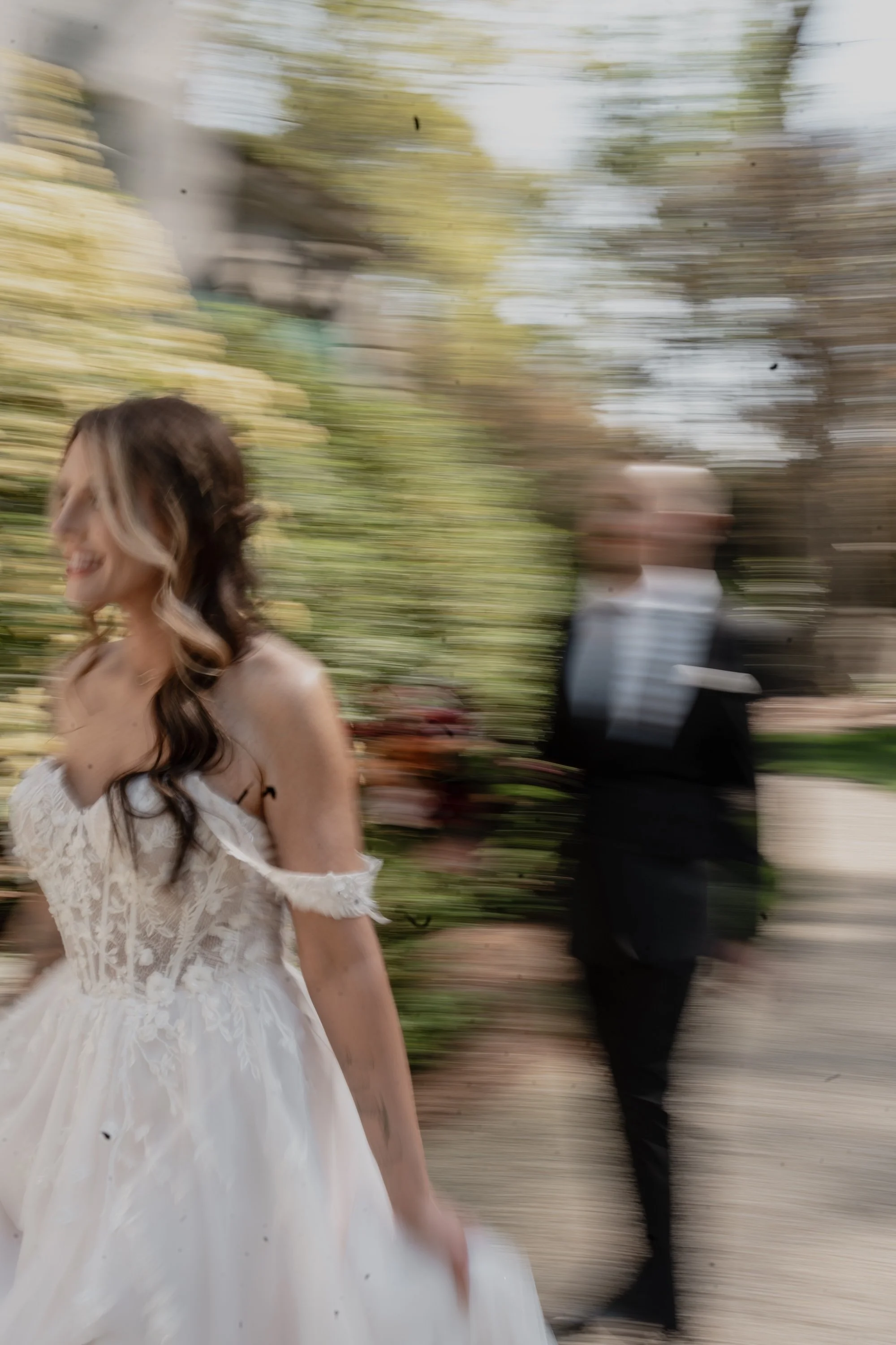 A bride moving through blurred motion, her gown catching light as if the day itself was in motion.