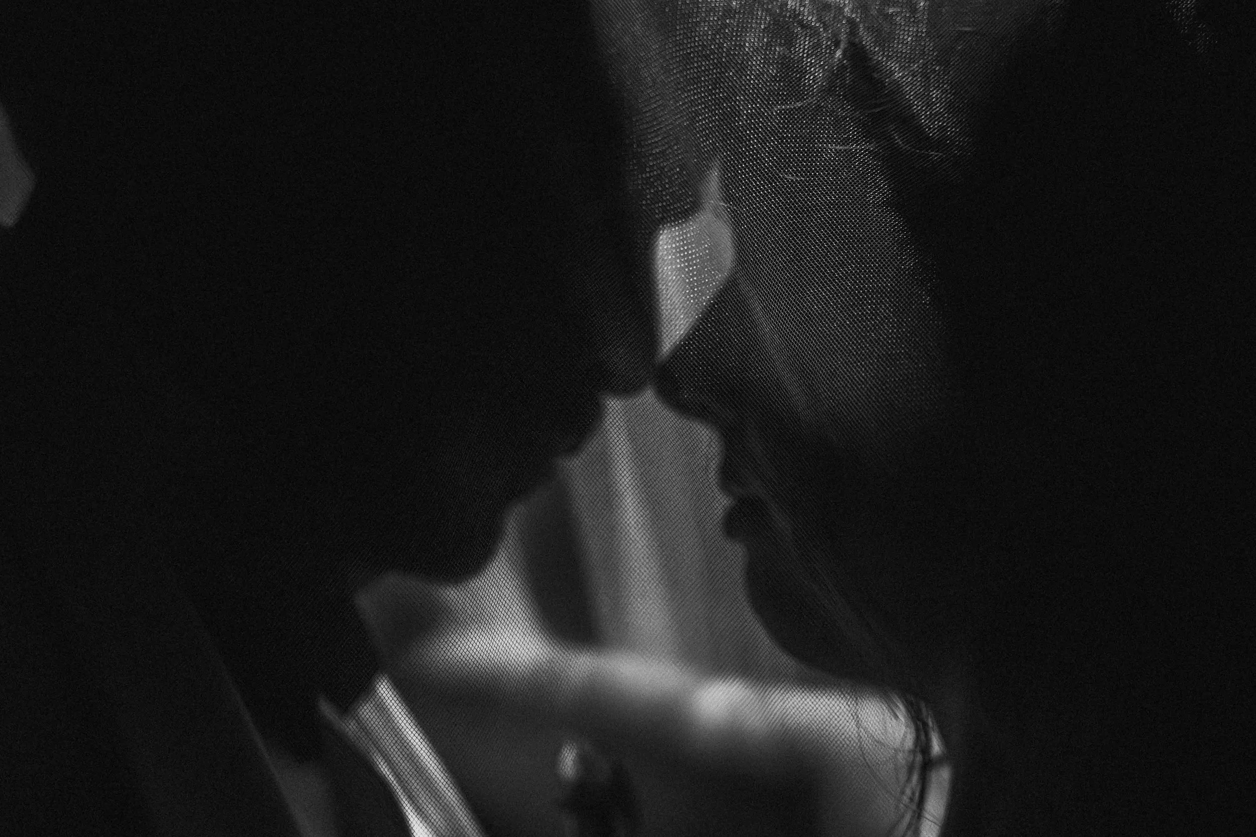 A man and woman stand close at a waterfall, foreheads touching as water falls behind them, framed quietly by the Fragmented Memories prenup photographer.