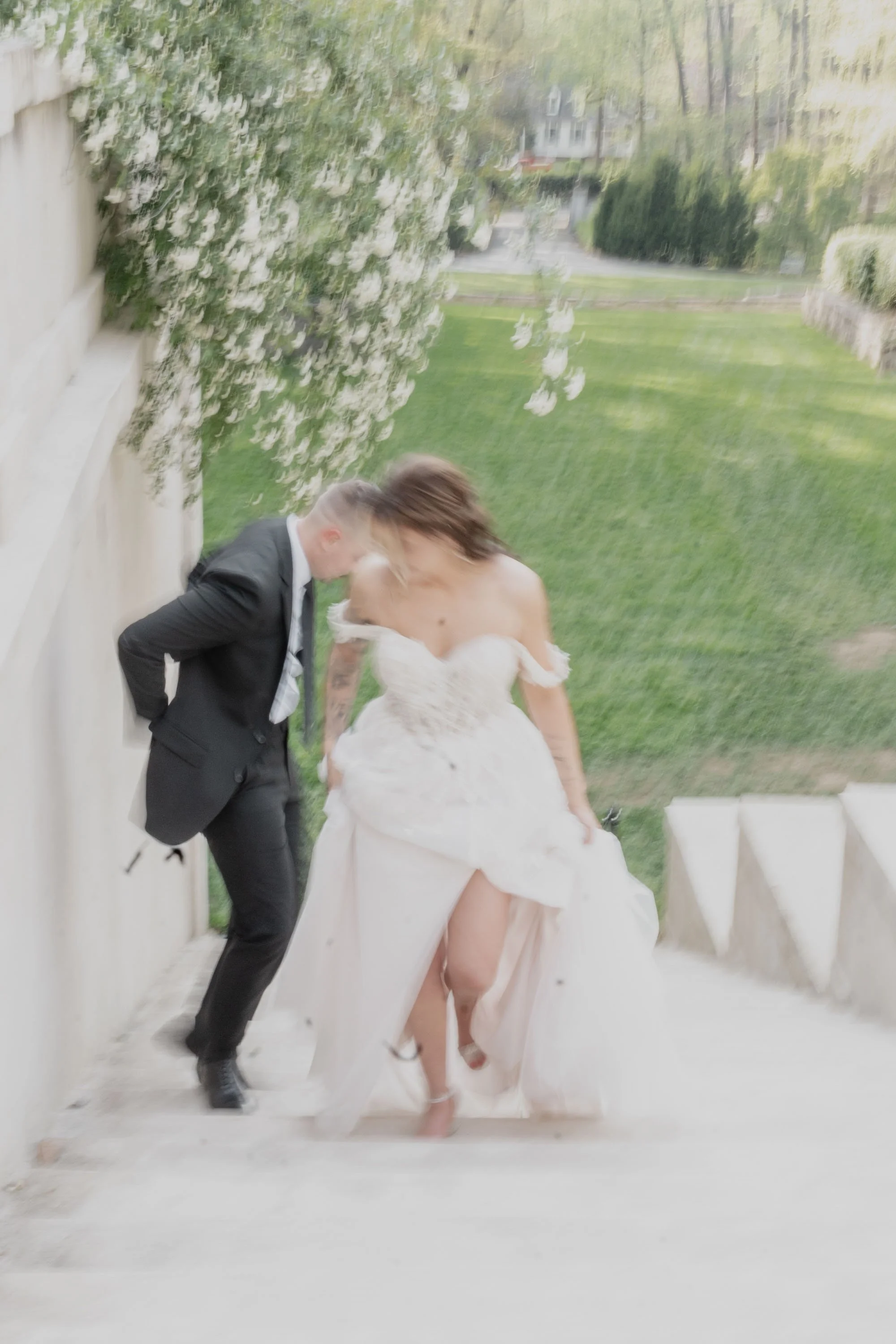 Couple walking hand in hand down stone steps, motion blurred to feel timeless, inspired by New York wedding photographer style
