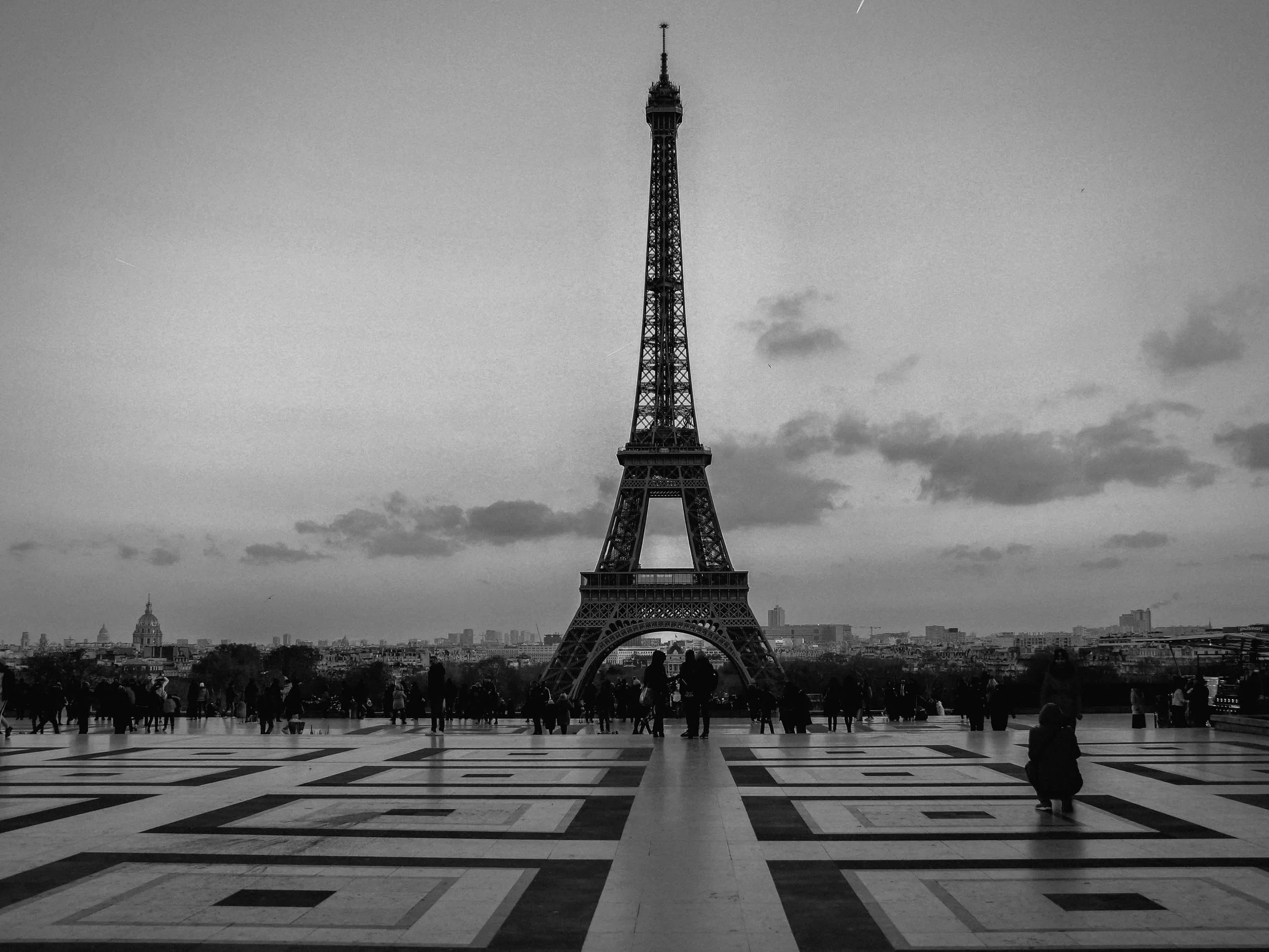 A cinematic view of the Eiffel Tower at dawn, framed in timeless black and white, captured by Palace of Versailles wedding photographer Caz Isaiah.