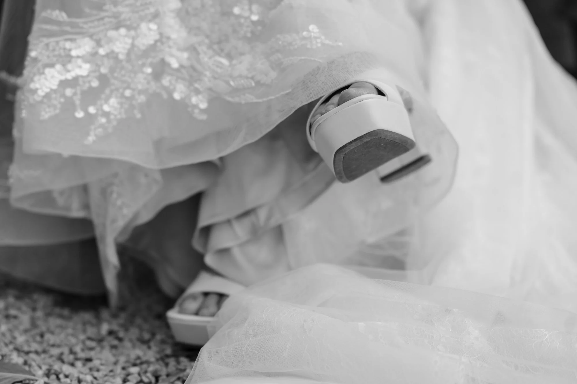 A close view of the bride’s veil and shoes arranged with poetic detail, highlighting textures and soft tones.