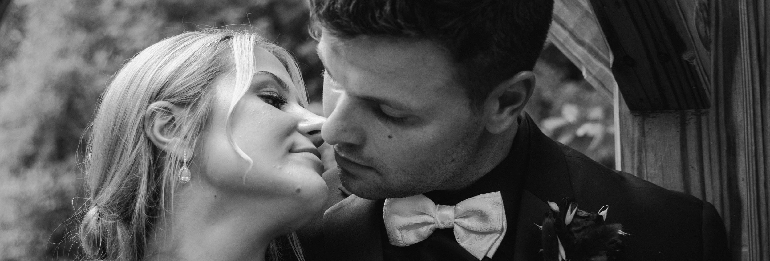 A bride leans toward a groom beneath a wooden beam, their faces close as a Fragmented Memories prenup photographer frames the moment tightly.