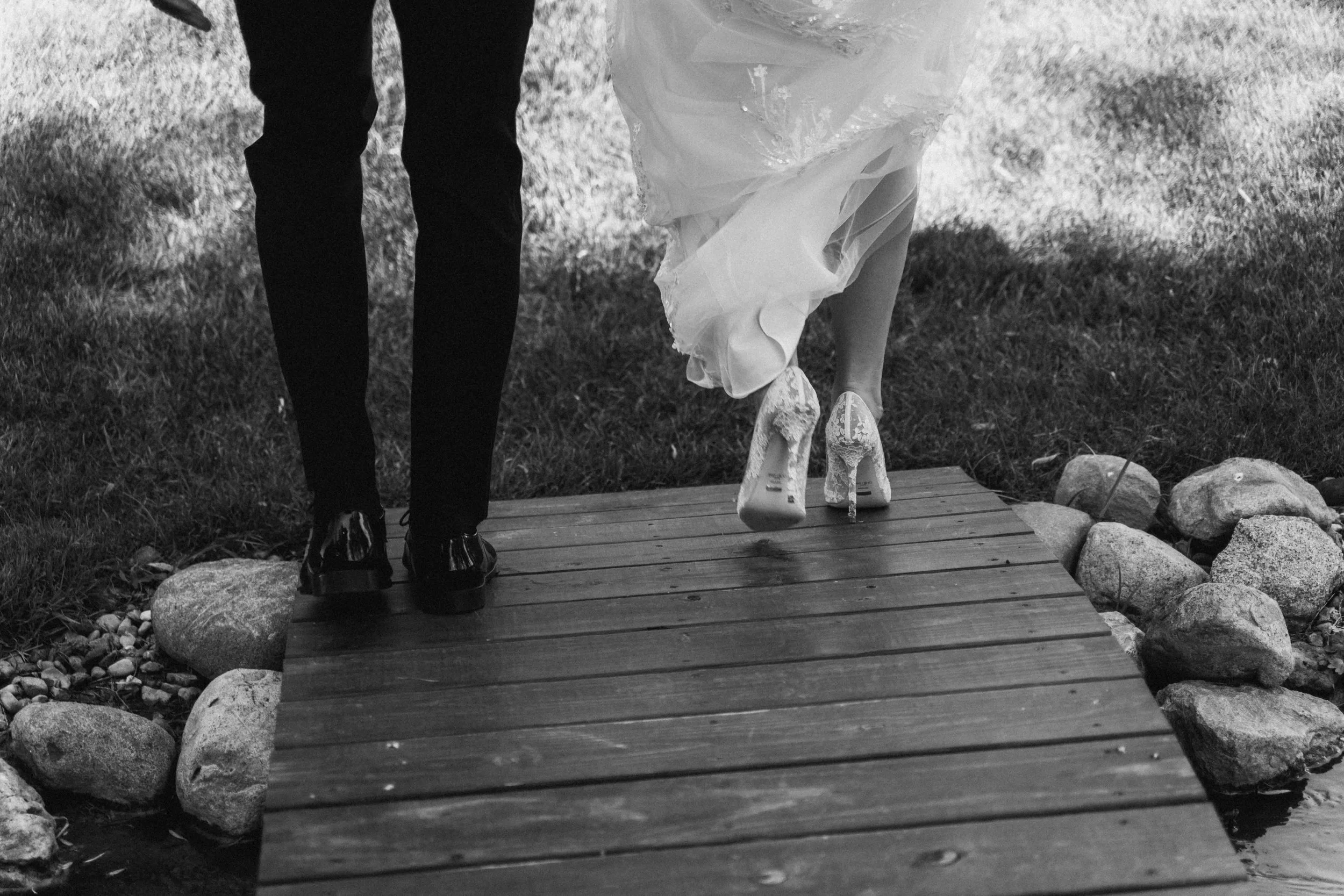 A bride’s gown brushes wooden paths as winter sunlight shimmers around her.