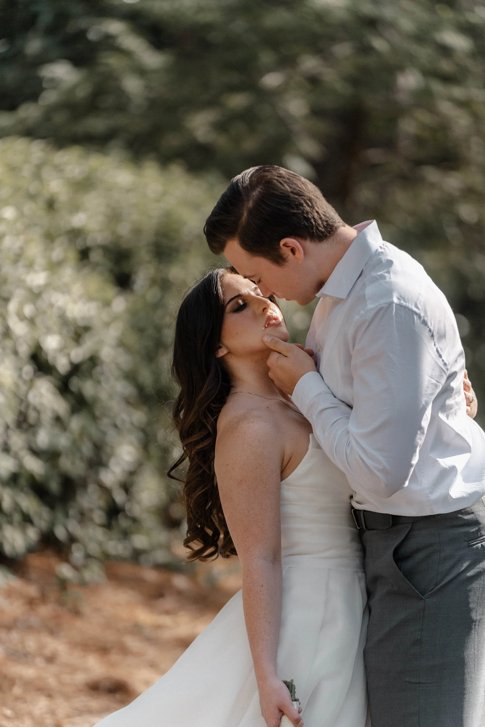 Groom leans in to kiss bride beneath soft natural light, romantic editorial moment by Norway Wedding Photographer.