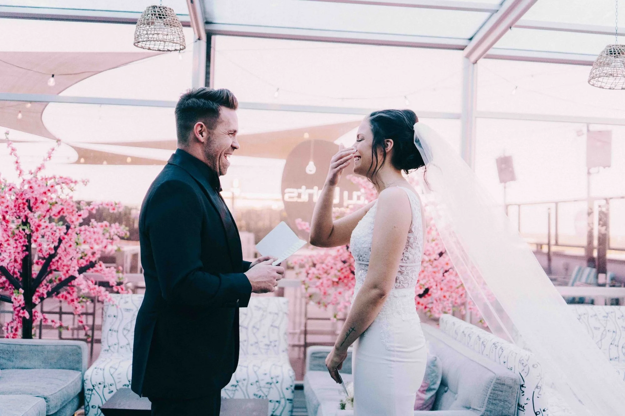 A groom looking at his bride during the ceremony, expressions carrying the weight of the moment, held with intimacy.
