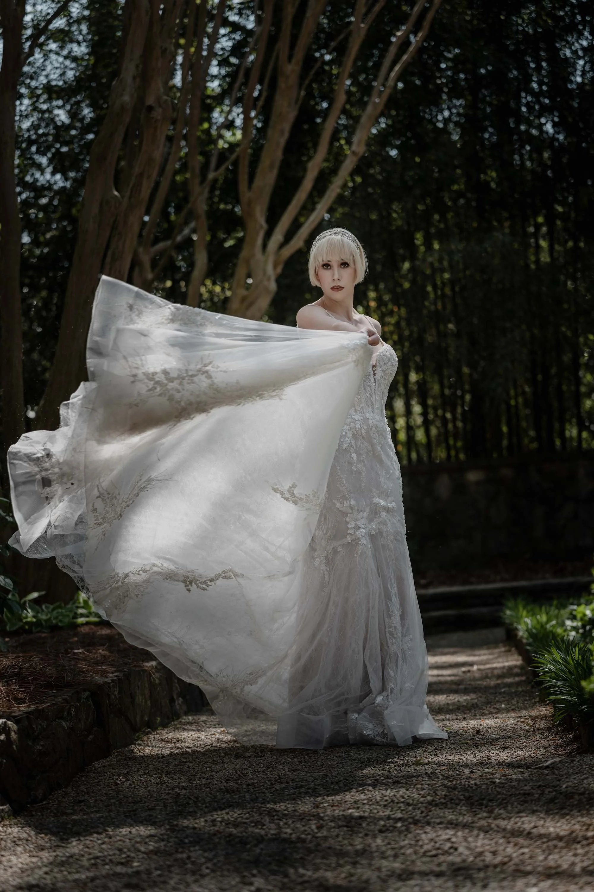 Bride lifts her gown as she moves through a forest path