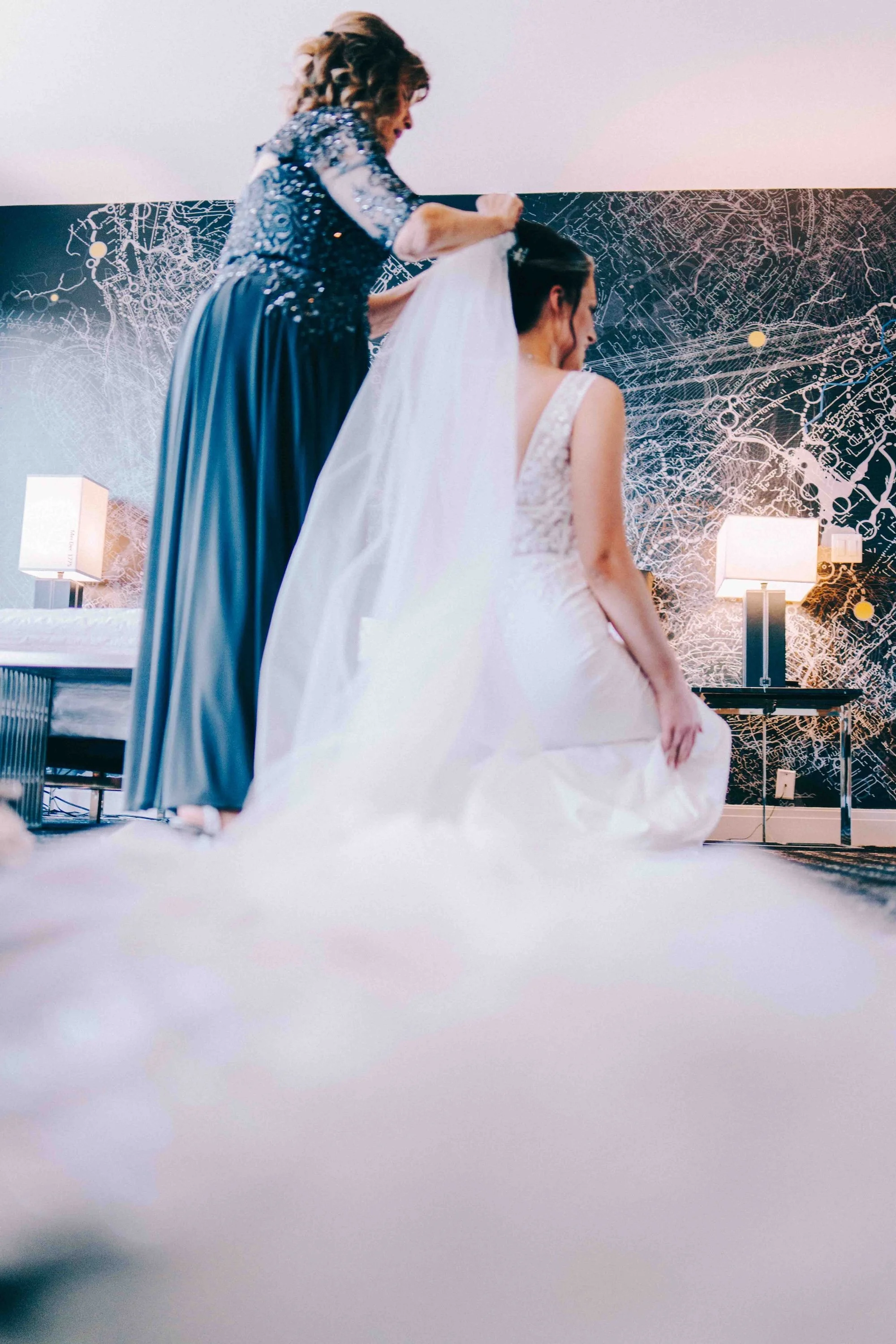 Bride and groom sharing a quiet embrace beneath softly draped fabric.