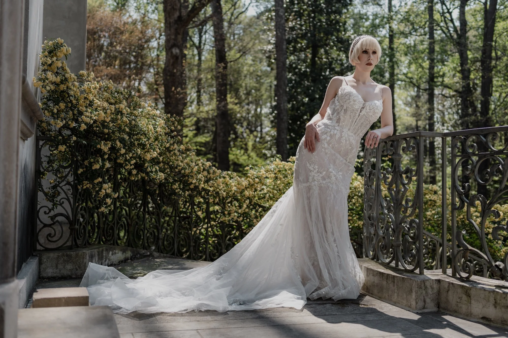 A bride framed against foliage, her gown flowing as she turns, the scene preserved with an editorial wedding photographer’s eye.