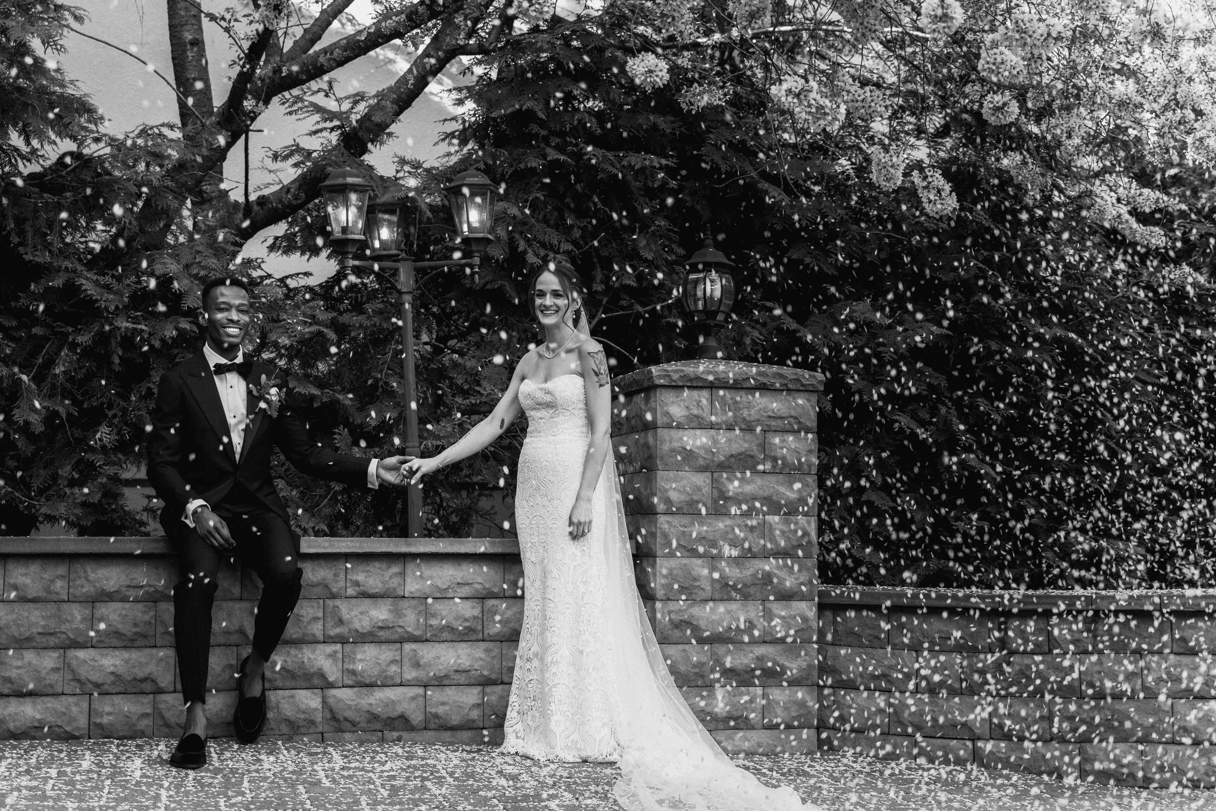 bride in groom with pedals from a. tree falling from them captured by Bali photographer, Caz Isaiah