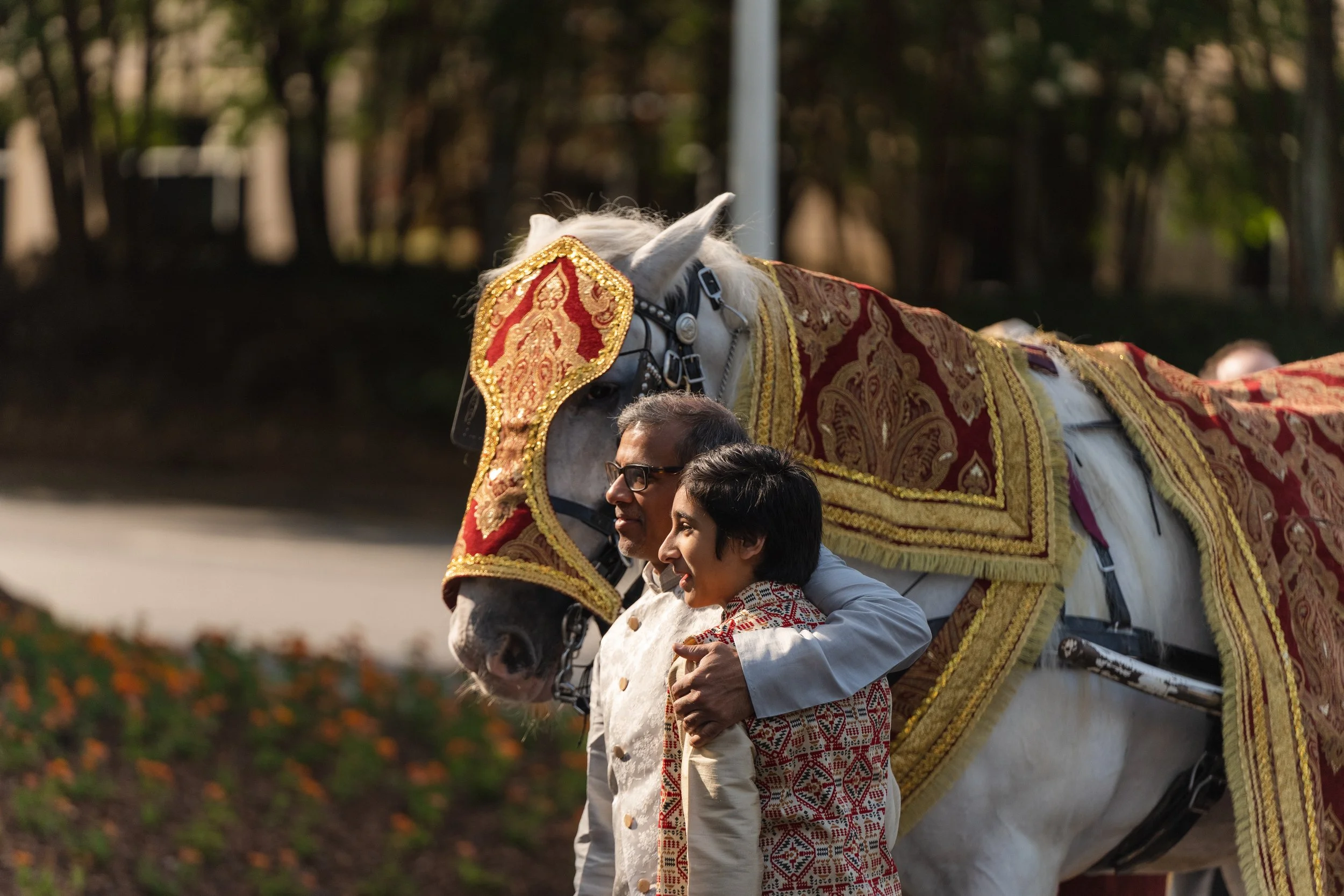 Bride and groom smiling at each other during their ceremony, framed by family and golden light — captured by Caz Isaiah, India Wedding Photographer
