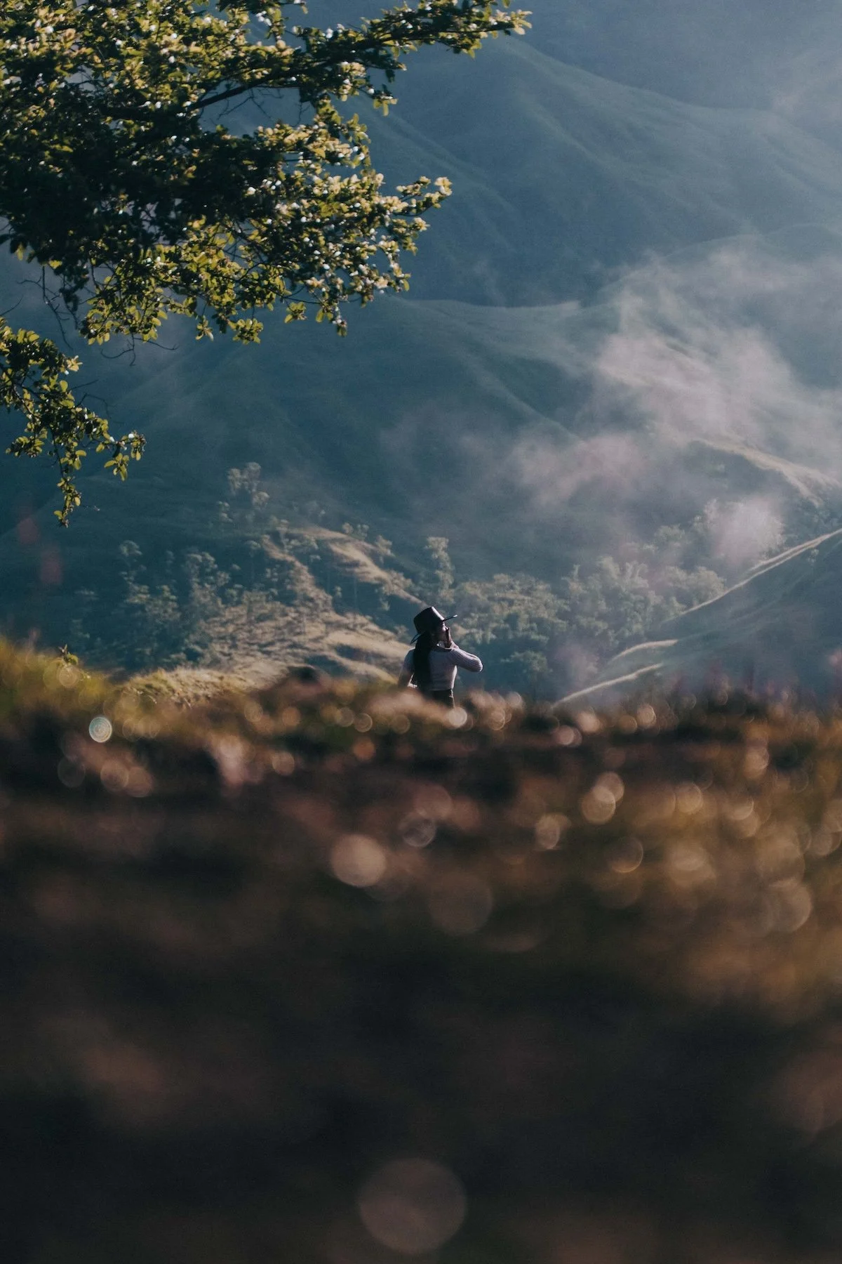SE Asian photographer documenting vows on a jungle ridge wrapped in rolling fog and golden light.