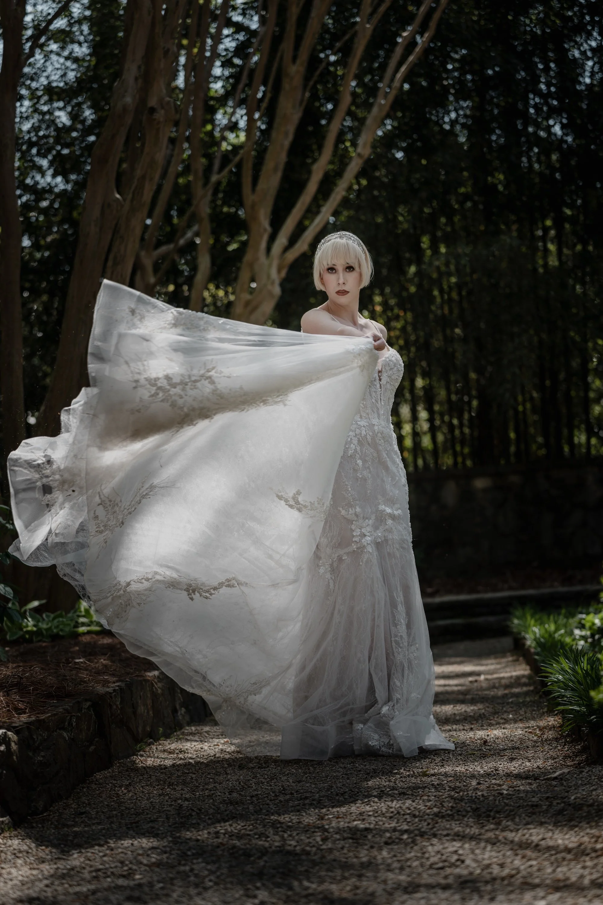 A bride twirling in her gown, fabric flowing like light through the garden air.
