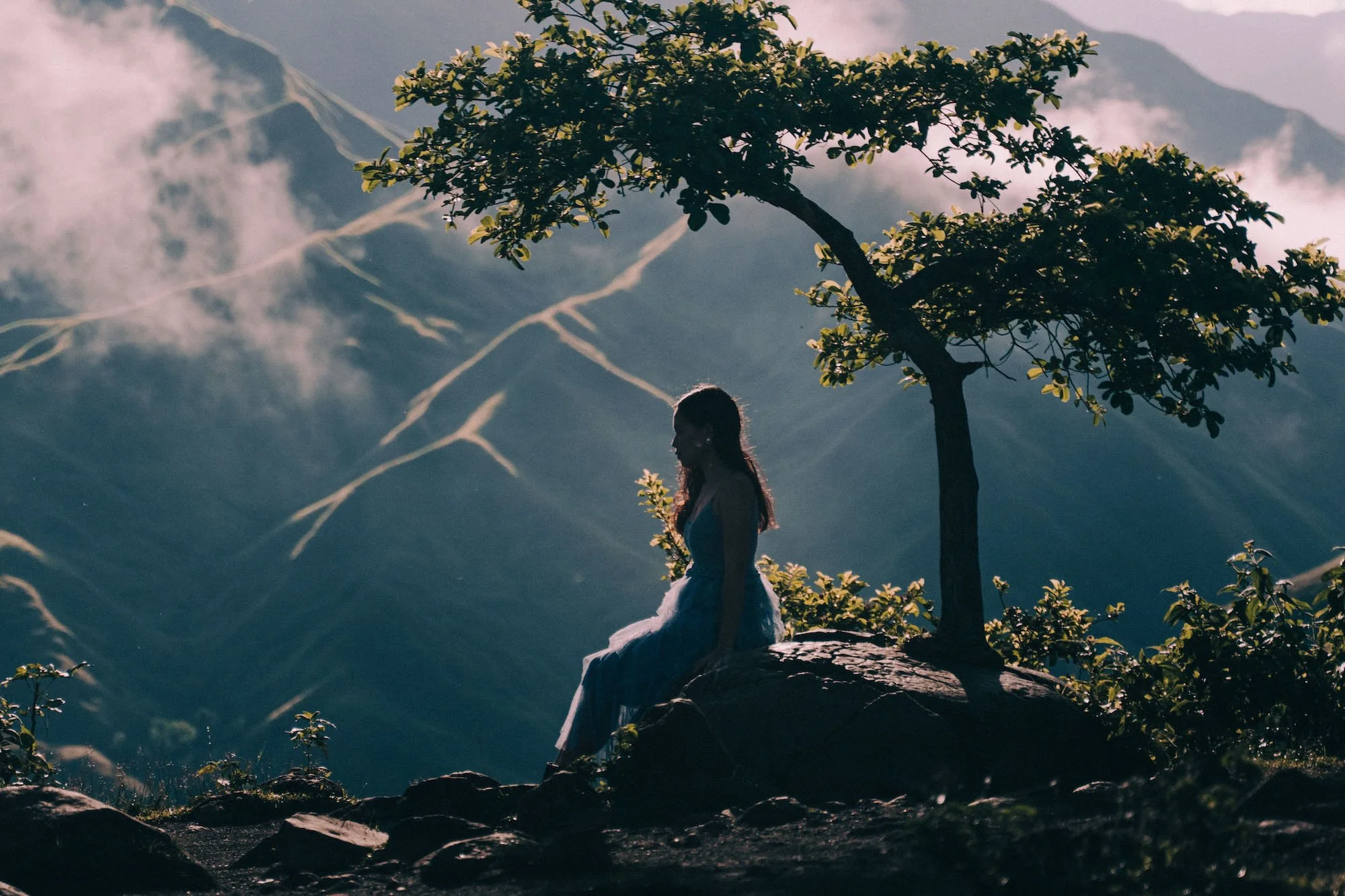 woman on a rock in misty mountains