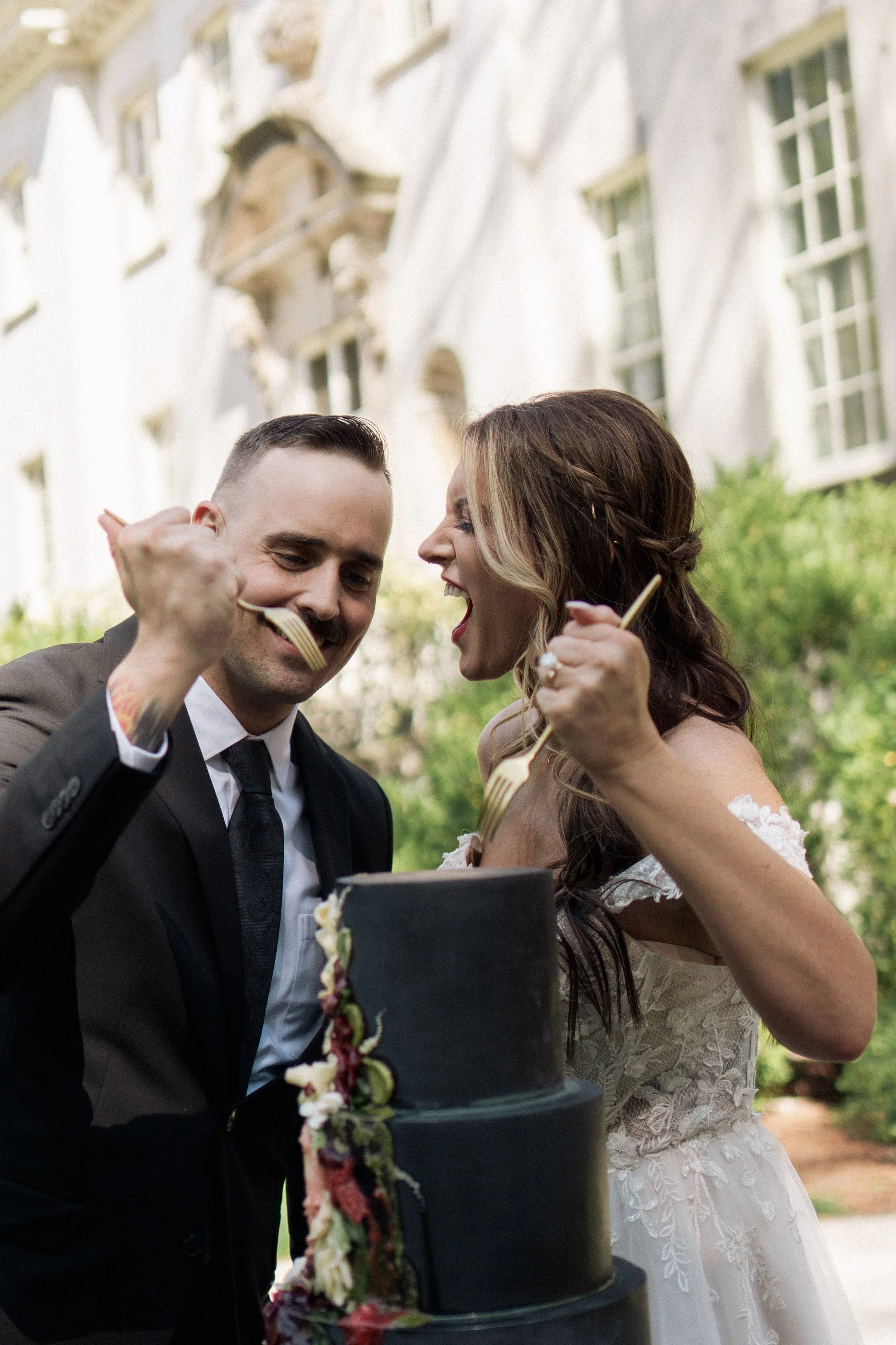 The groom raising his fork in celebration while holding his bride close, a stylish editorial capture from a luxury Destination Wedding Photographer.
