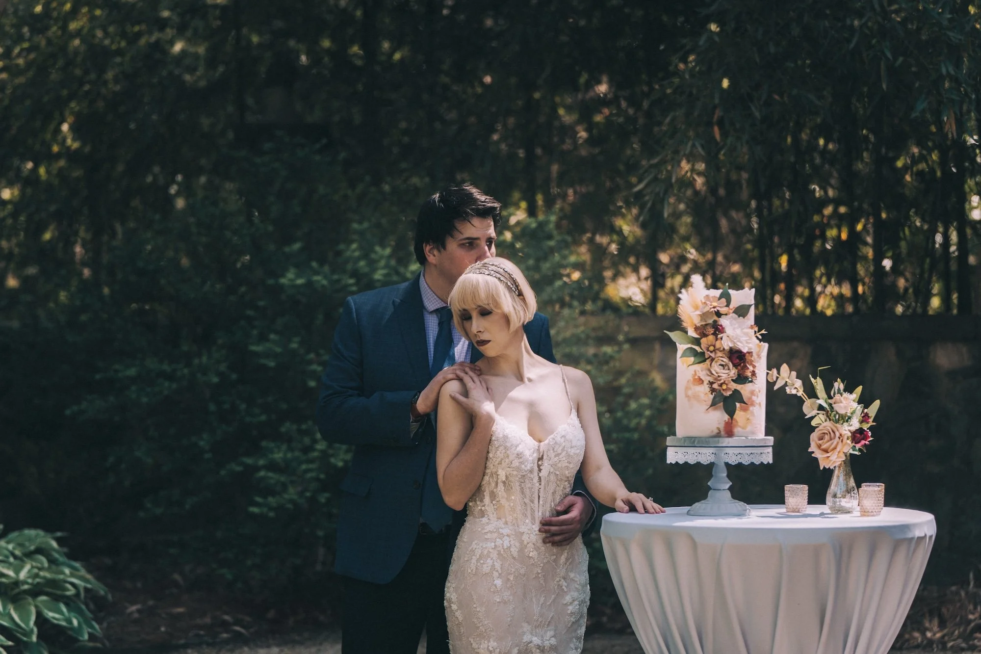 A couple shares laughter beside a cake table outdoors, the scene held with an editorial intimacy, part of a Kyoto inspired wedding setting.
