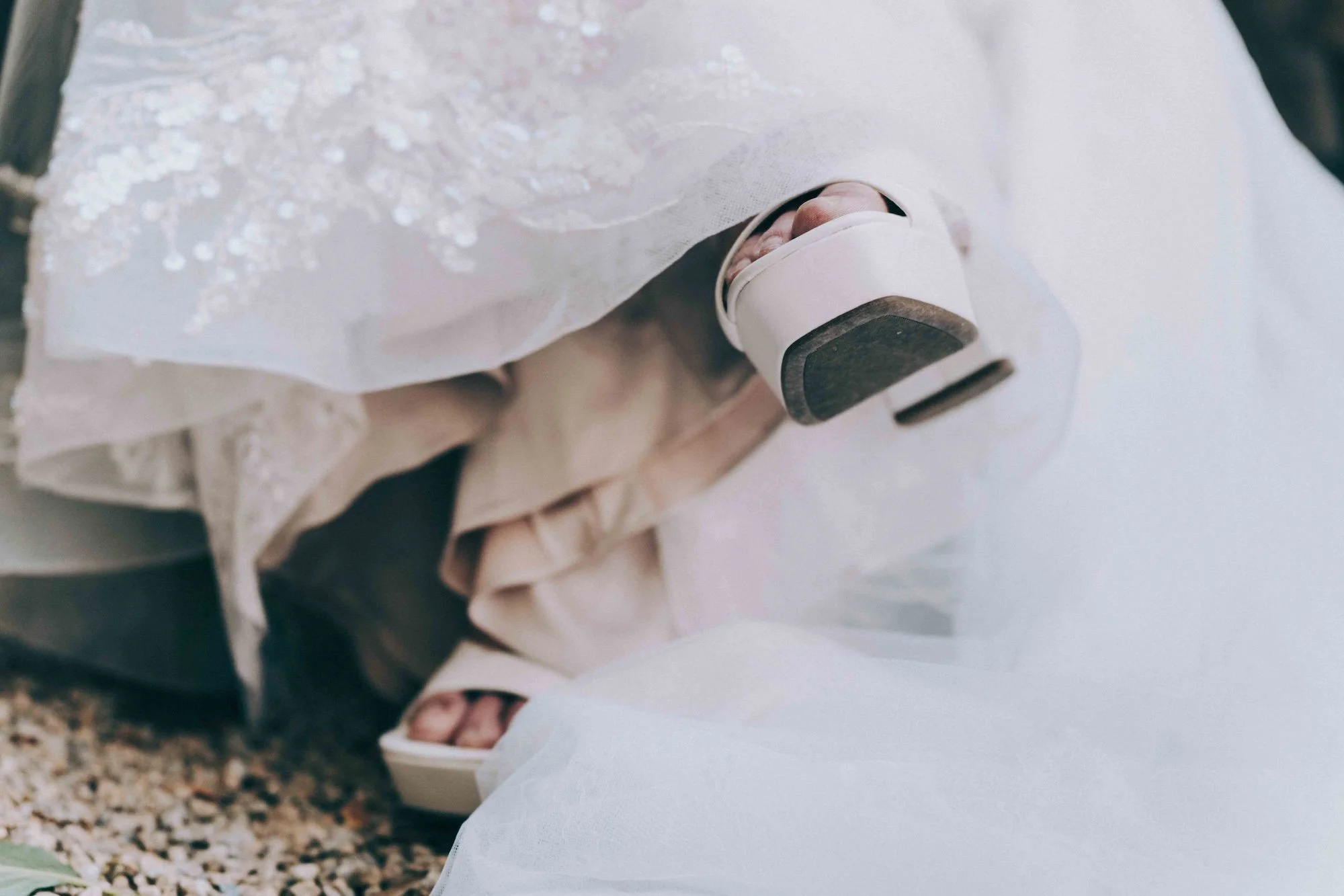 Bride’s shoes and lace gown captured in a styled still life, cinematic minimal detail