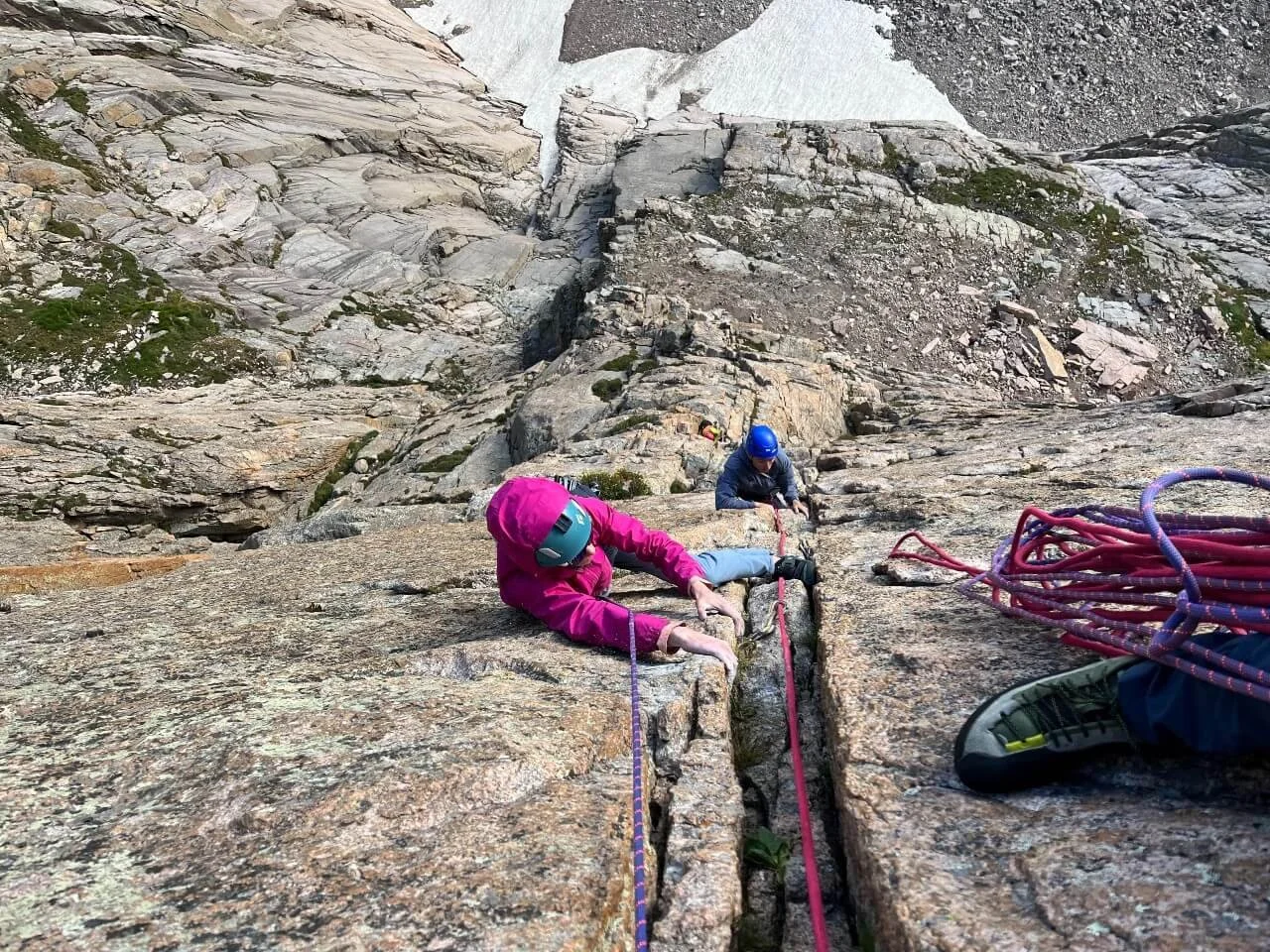 Climbing steep cracks with the guide belaying from above on the Casual Route on the Diamond.
