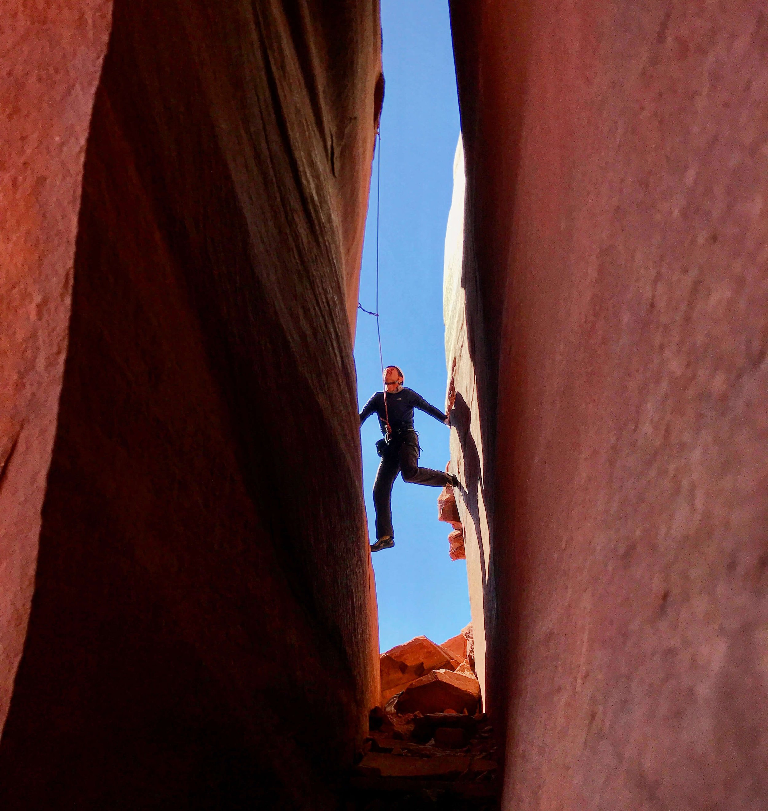Climbing a full body chimney at the Utopia area.