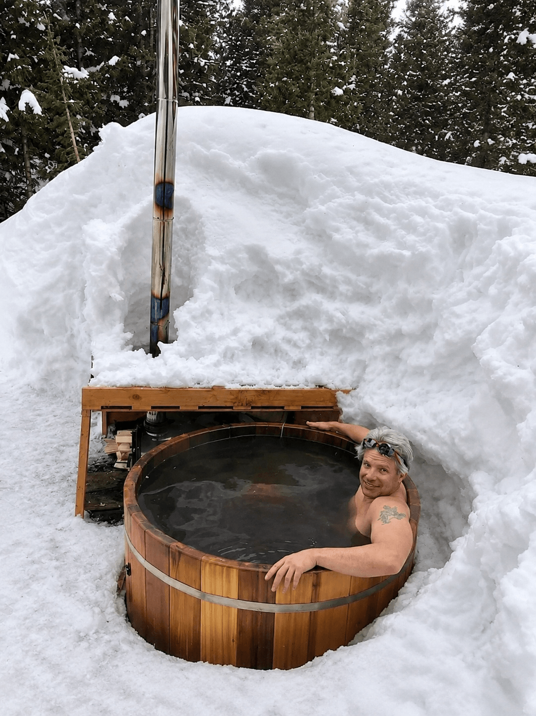 A skier enjoys relaxing in the wood-fired hot tub after a day of skiing the backcountry around Hayden Lodge.