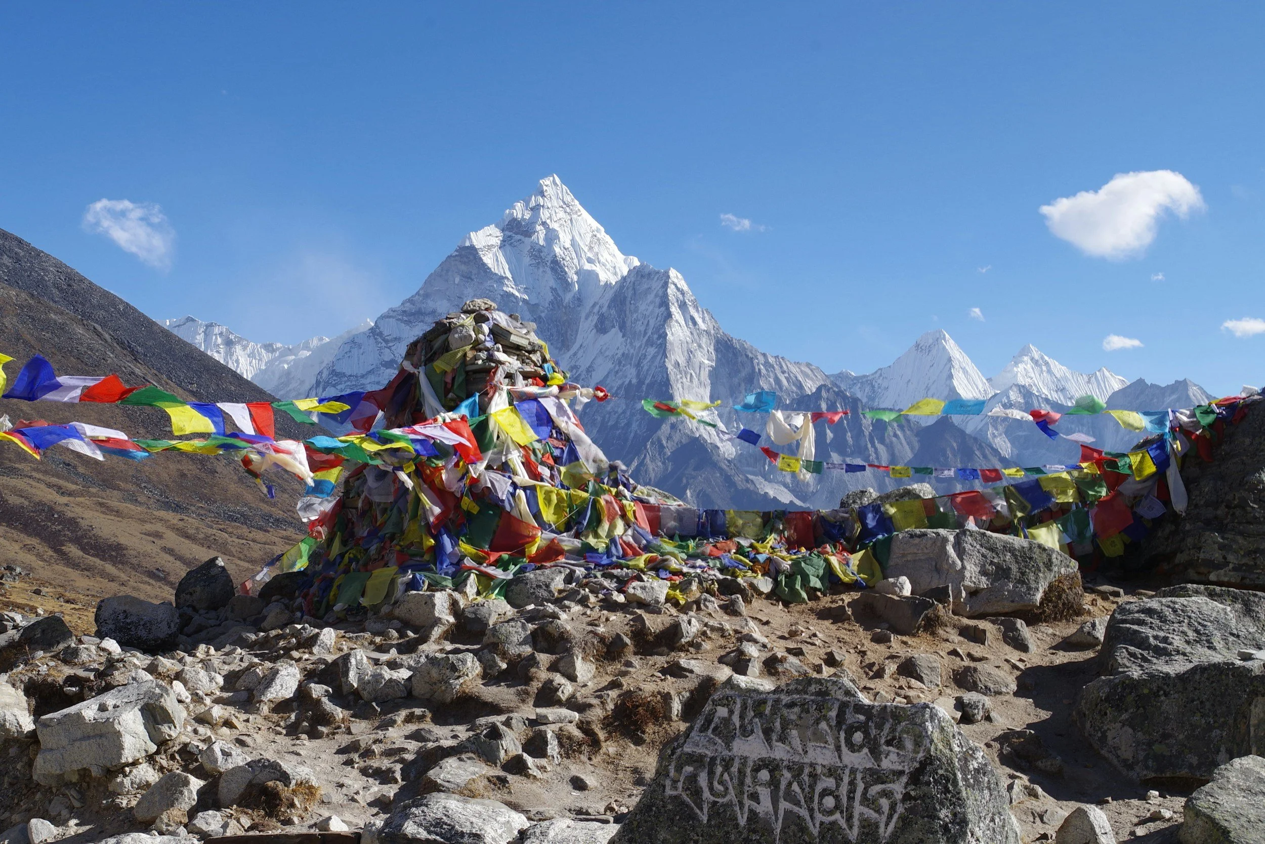Ama Dablam rises out of the Khumbu Valley with Tibetan prayer flags in the foreground.