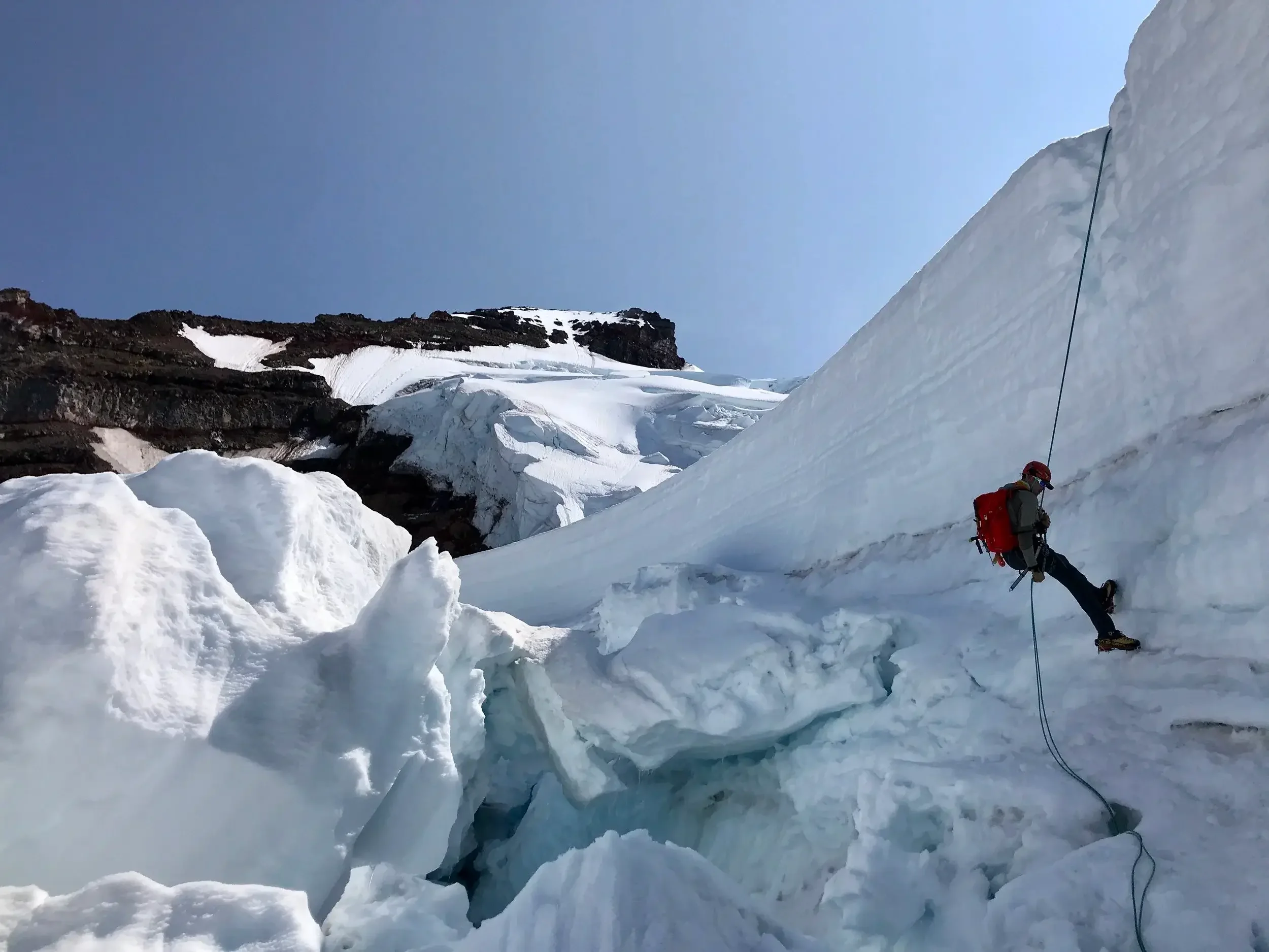 Rappelling over a large crevasse on the descent from the North Ridge.