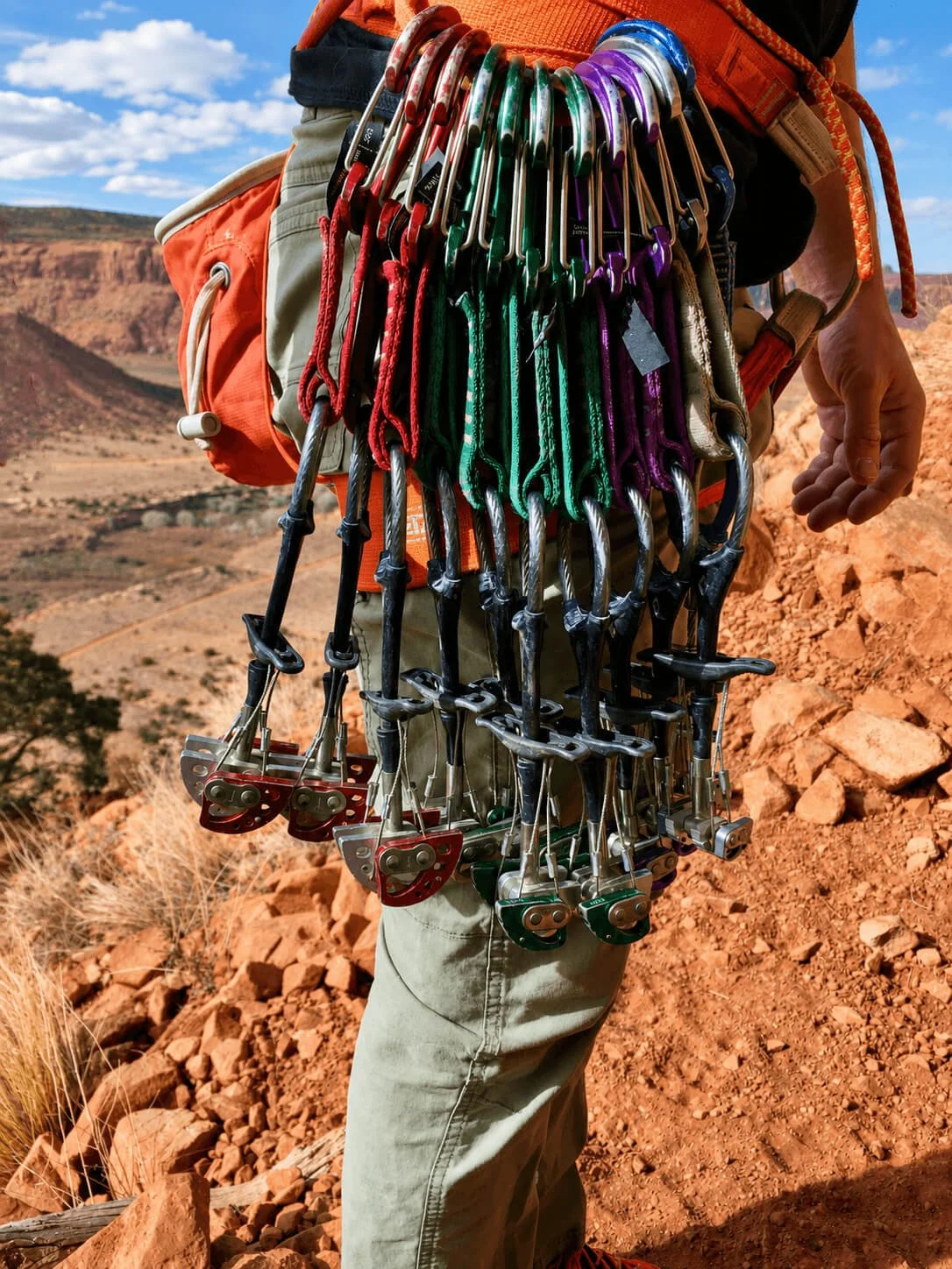 A guide's rock climbing rack with Black Diamond cams on his harness before climbing a route in Escalante Canyon during a crack climbing course.