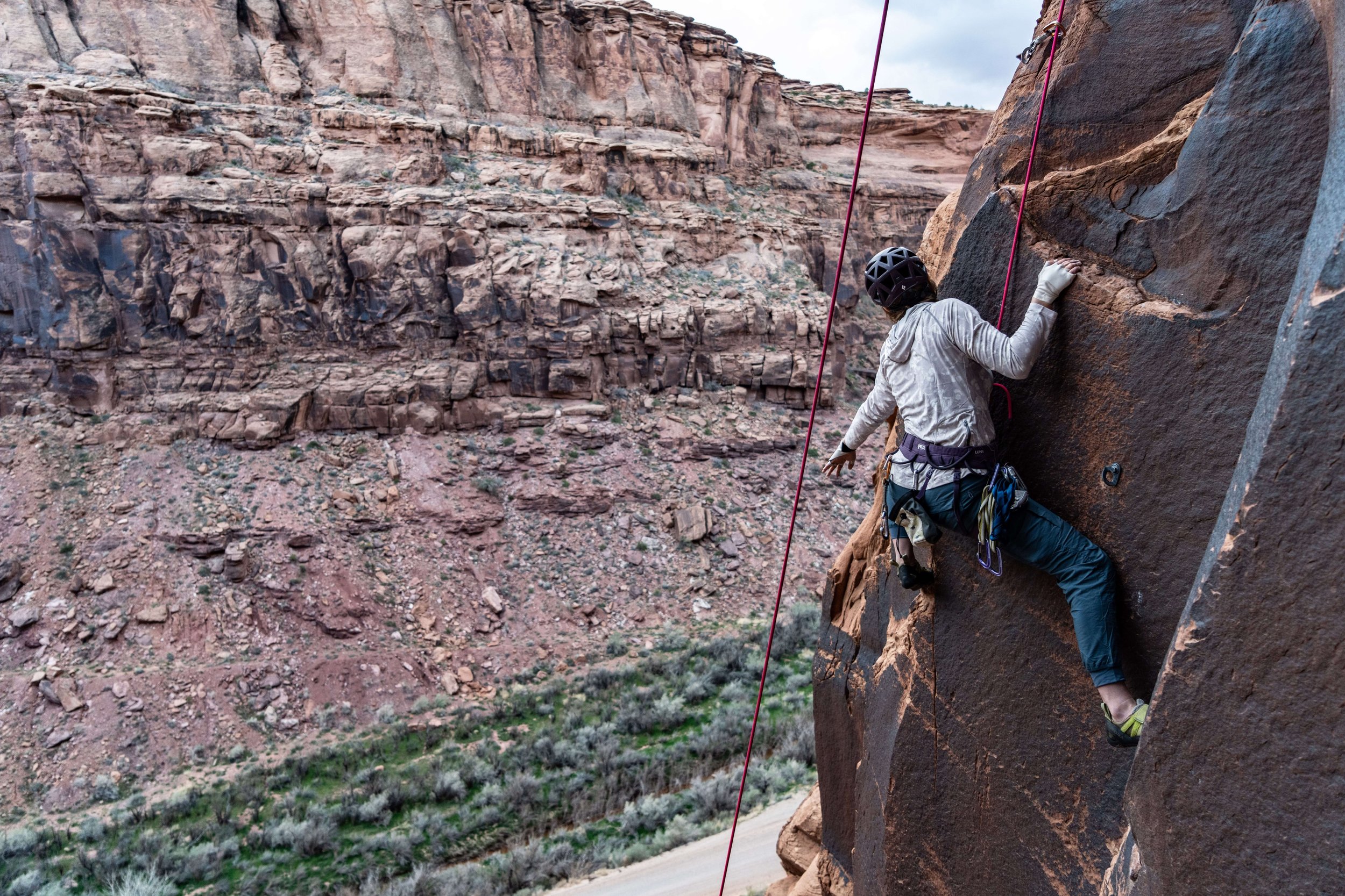 A woman is climbing with a guide at the Ice Cream Parlor in Moab, Utah.