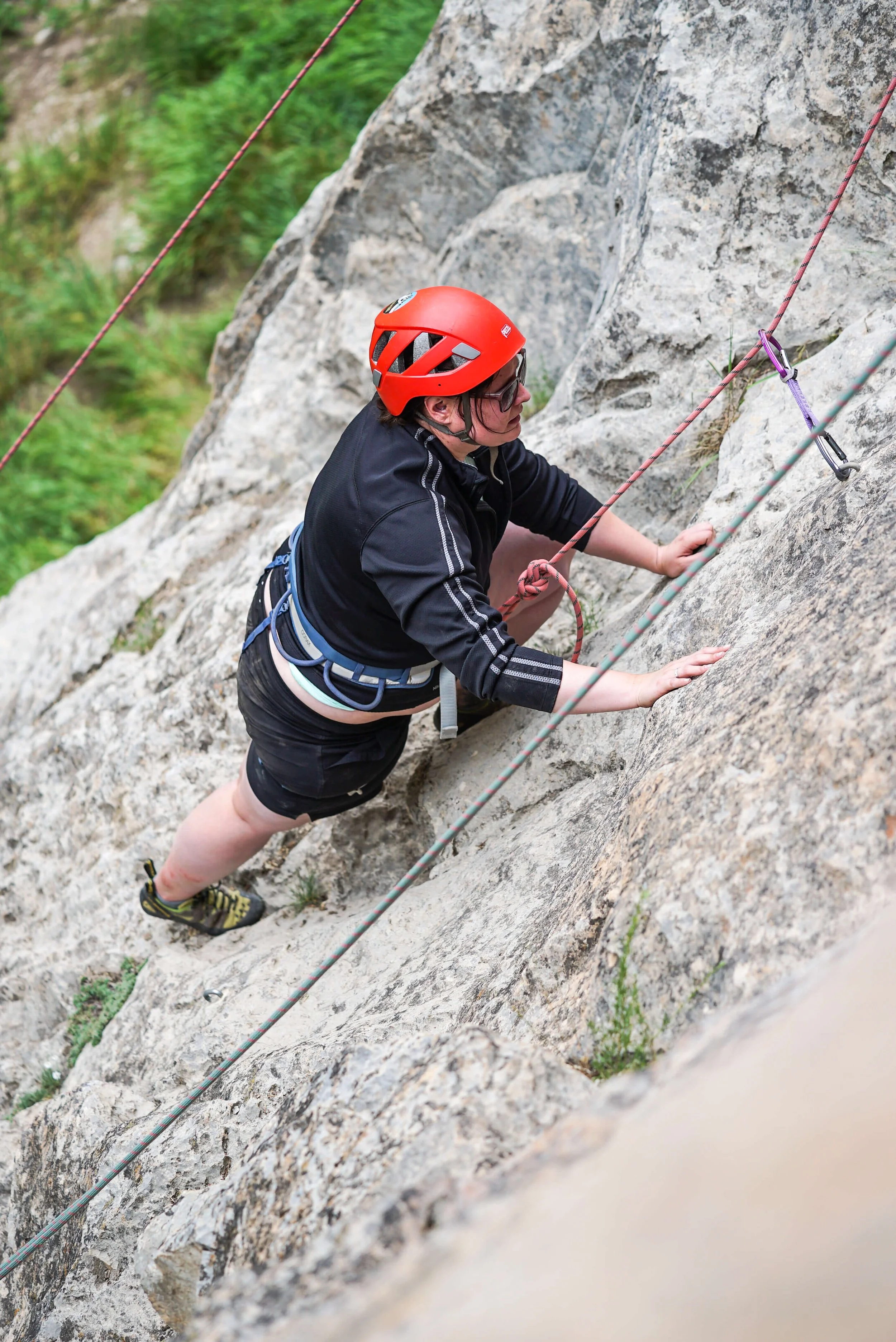 A woman is climbing up an easy toproping route in Rifle Mountain Park.