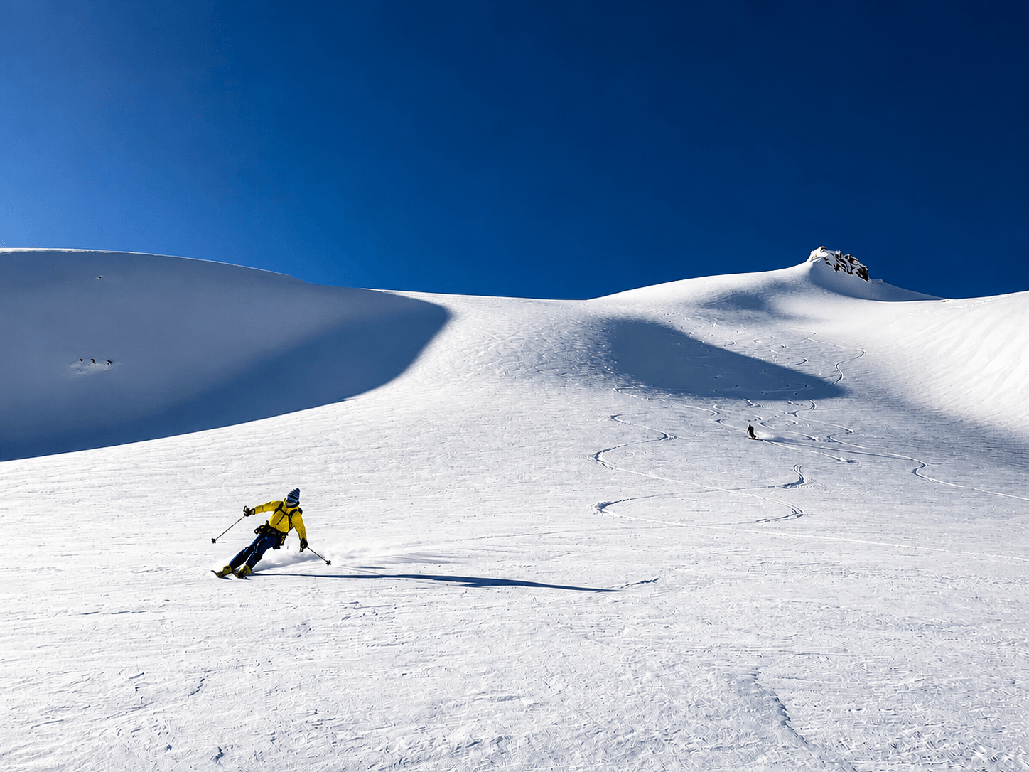 A skier carves a turn on the glacier during the Haute Route tour.