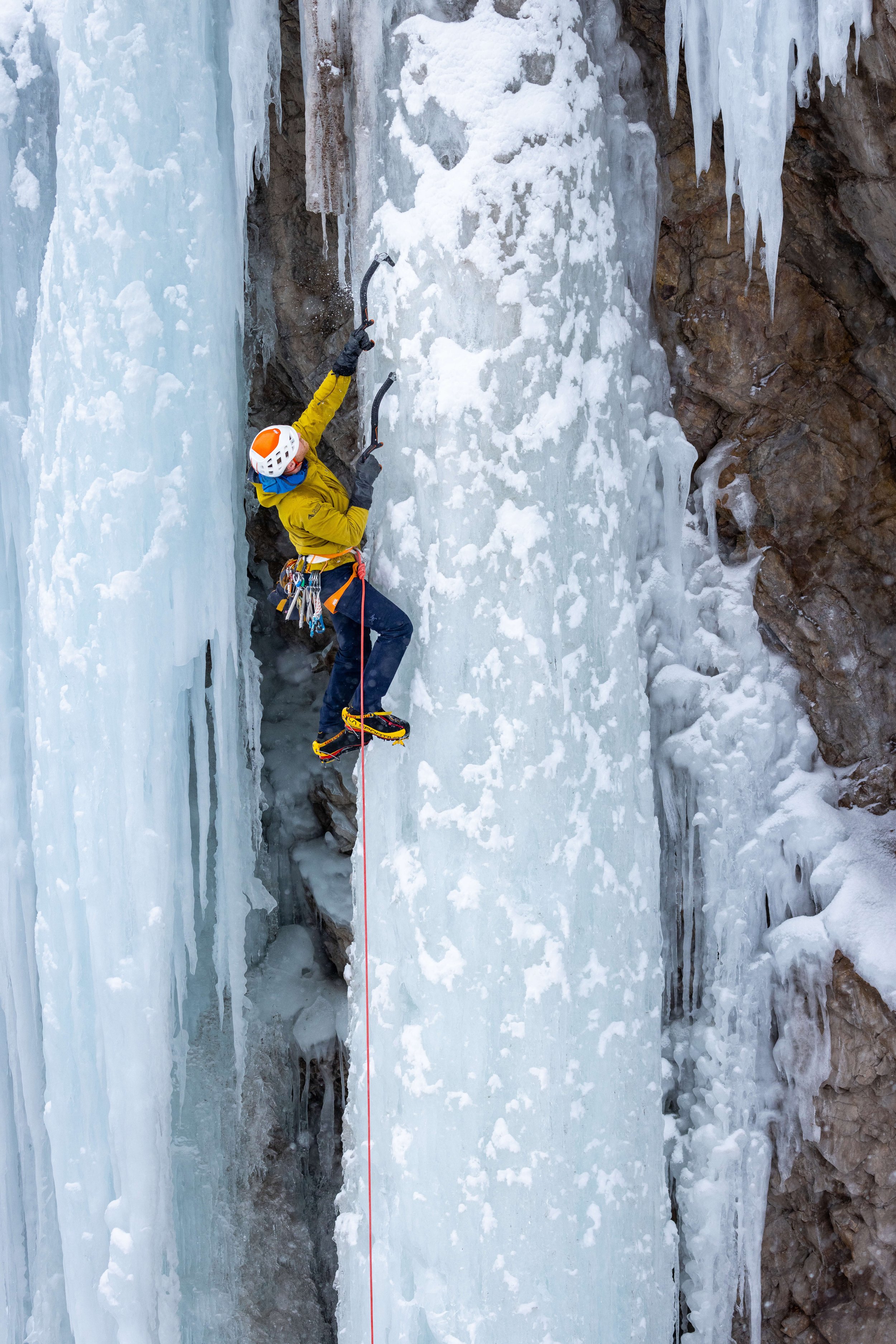 A guide leads a steep WI5 pillar in the Ouray Ice Park during a Steep Ice Climbing course.