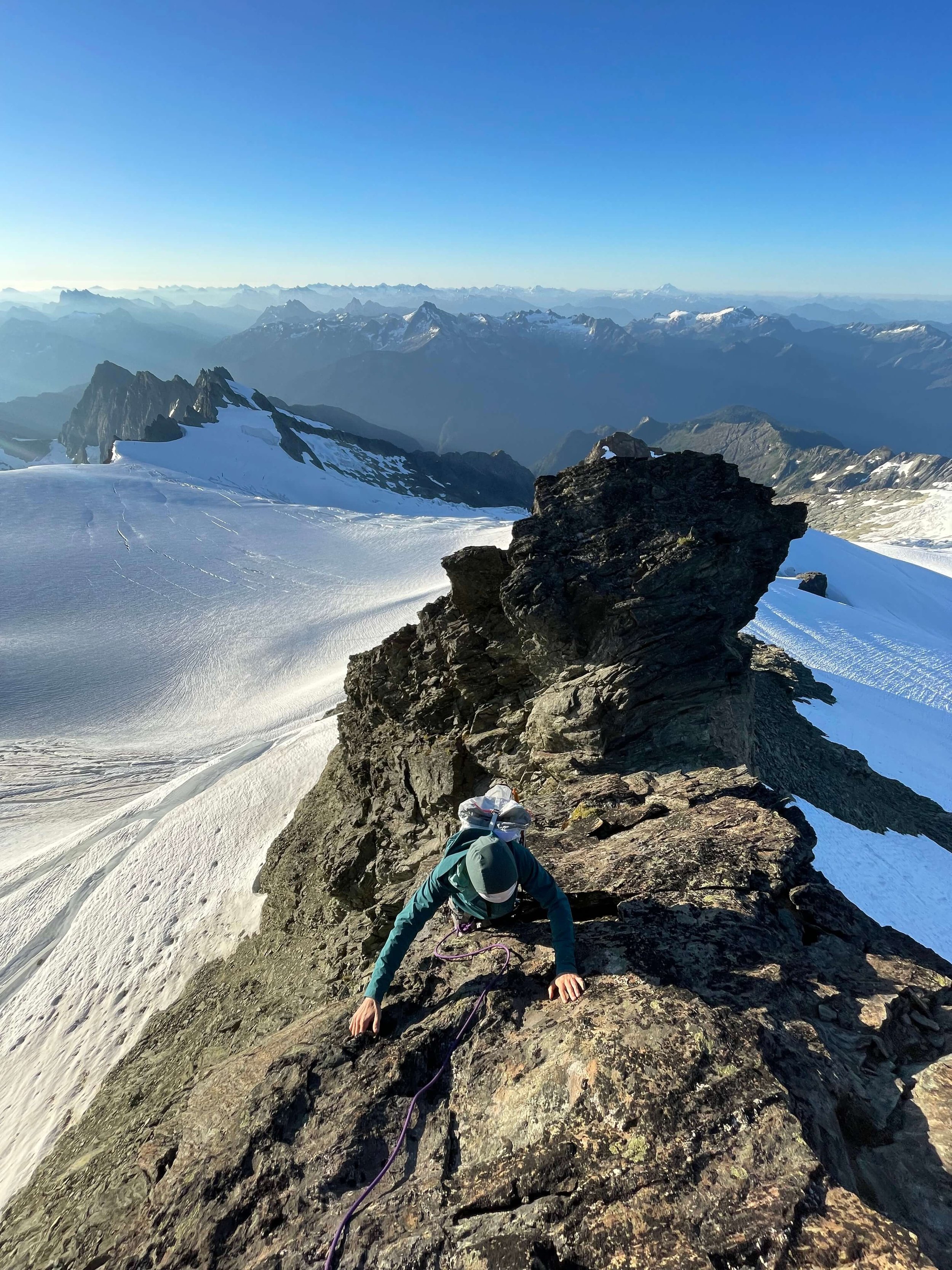 Climbing the SE Ridge with the sun rise lighting up the glacier below.