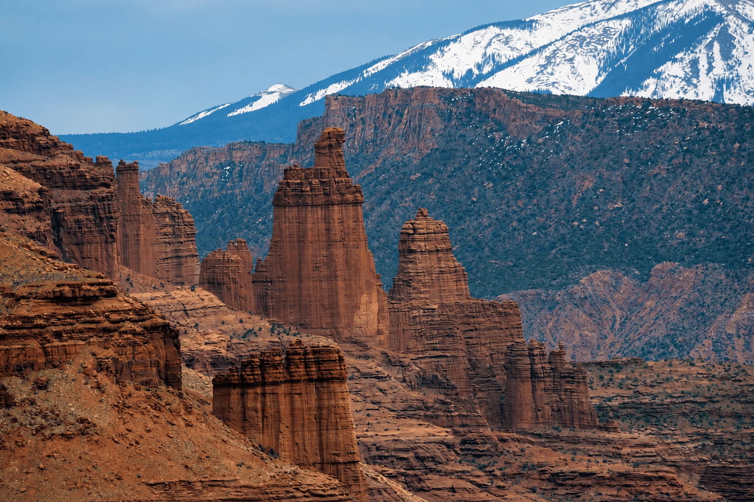 View of the Fisher Towers with the snowy La Sal mountains in the background, outside of Moab, Utah.