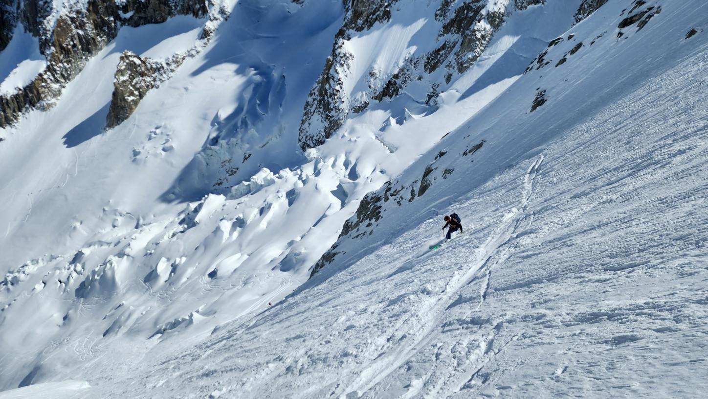 A skier is turning on a steep stope on a glacier during the Haute Route traverse.