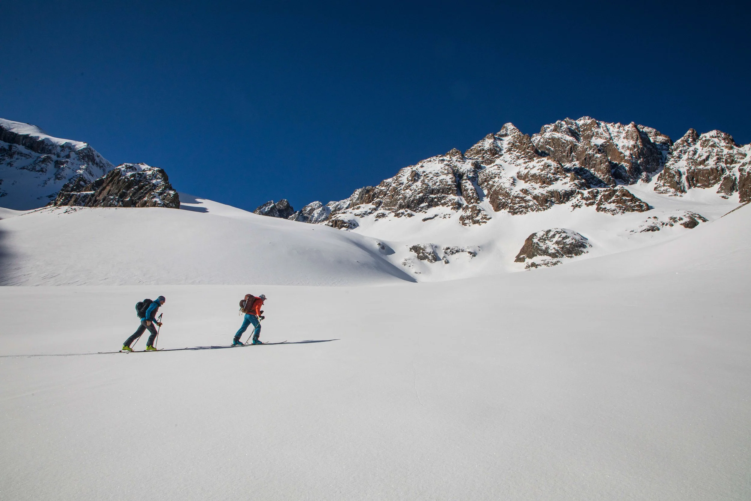 Two backcountry skiers are touring across a slope in the San Juan Mountains. 