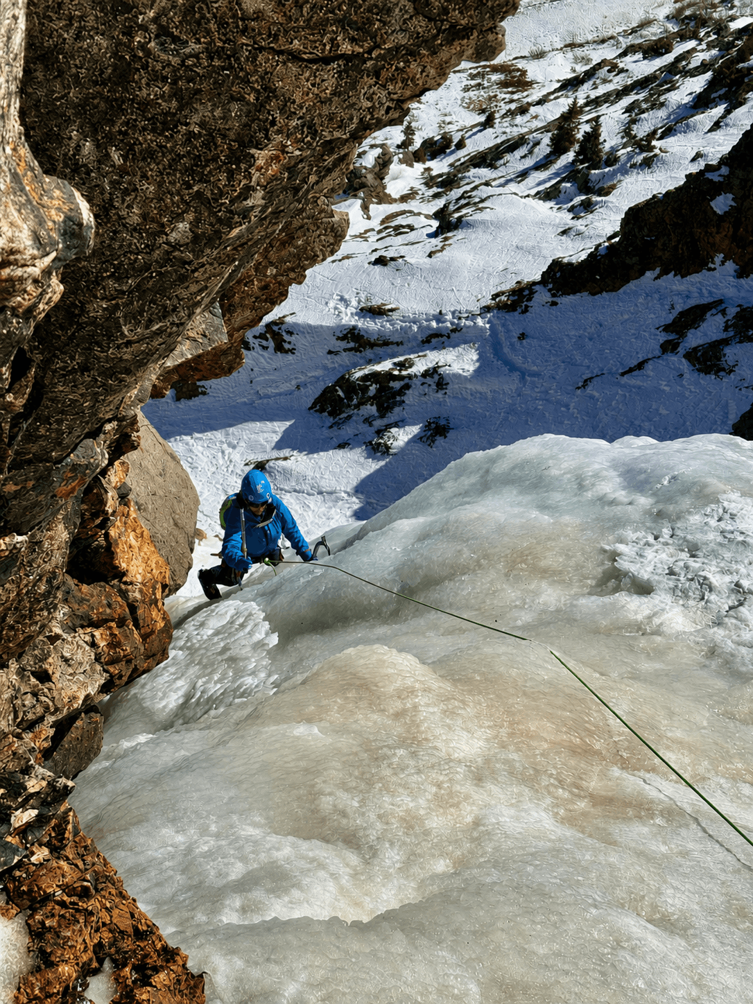 A climber is following the route, Goldrush, in Eureka, Colorado as the sun hits the ice turning it a warm yellow color.