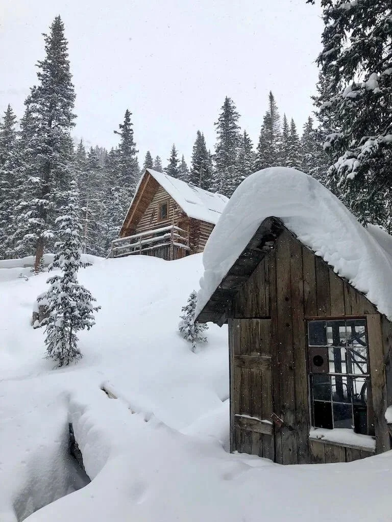 View of the Hayden Mountain Backcountry Lodge with deep powder snow.