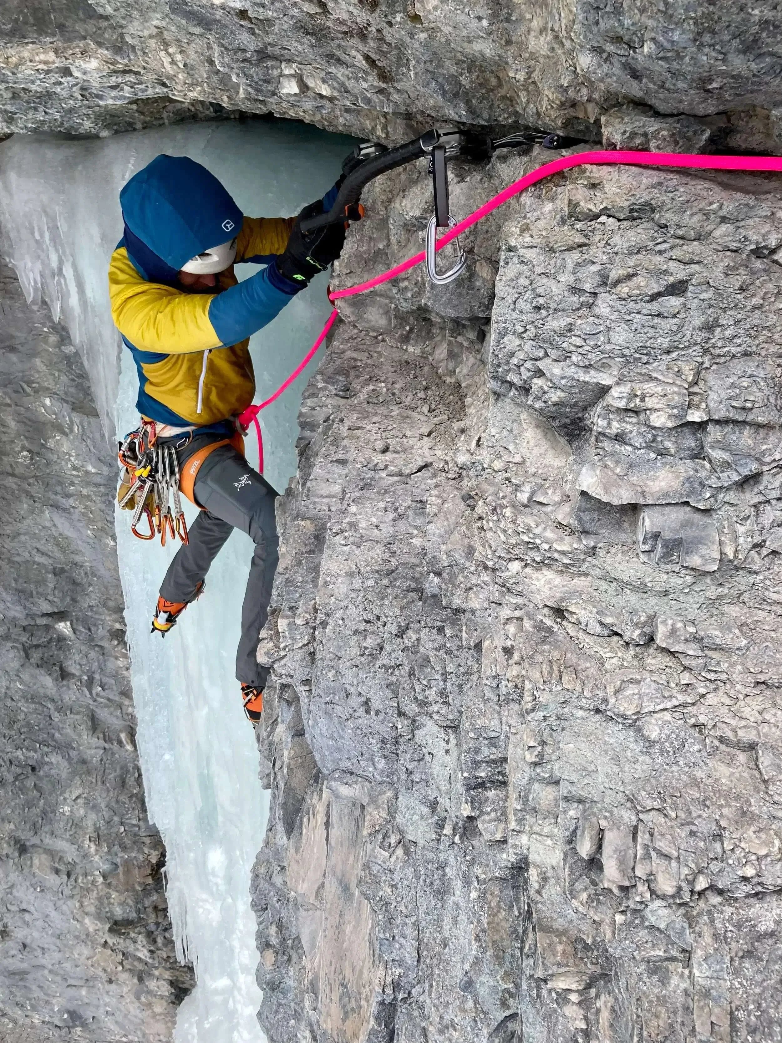 A climber traverses under a rock roof during a Mixed Climbing course at the Skylight area in Ouray.