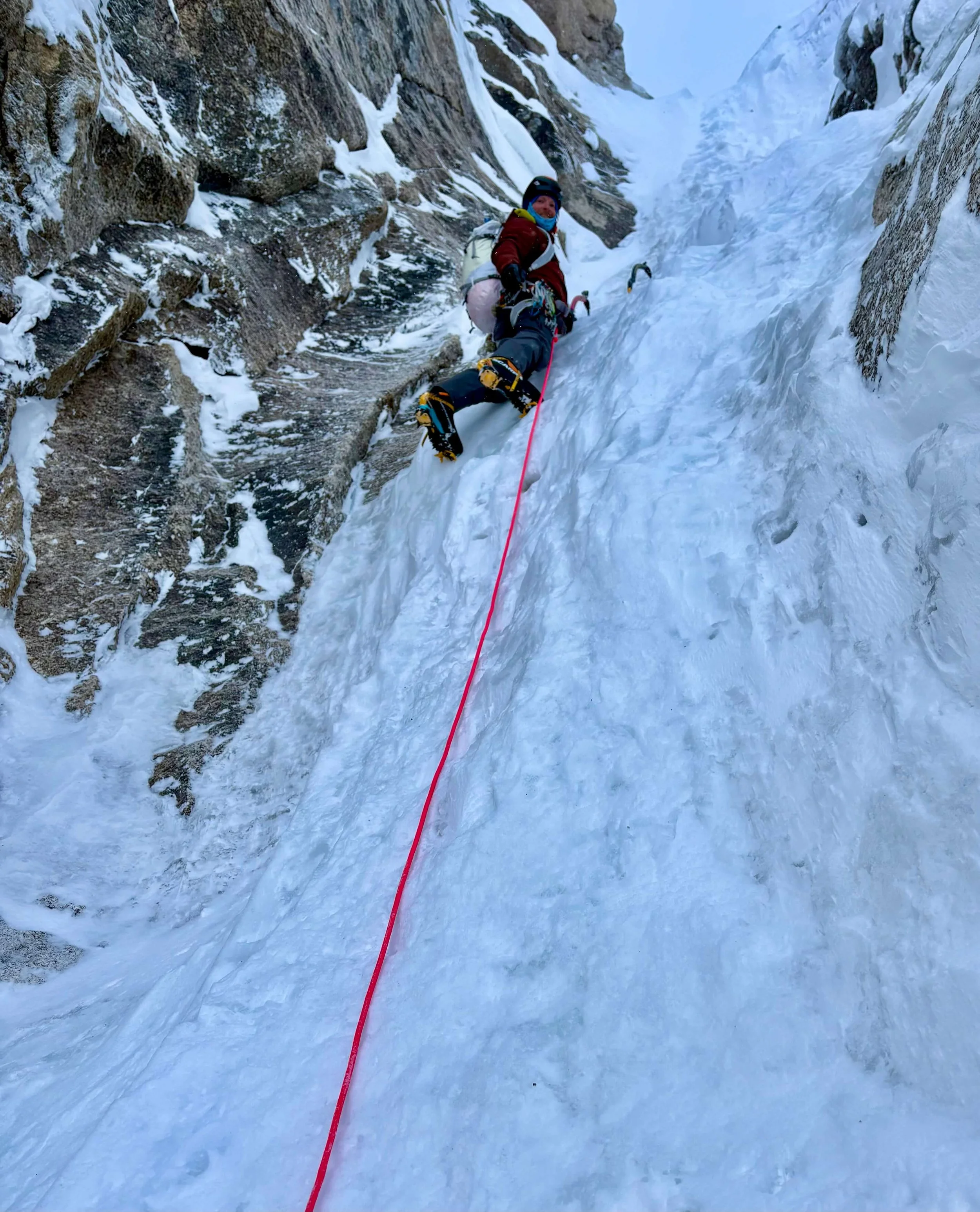 A Skyward Mountaineering guide is leading the crux pitch on Ham and Eggs. A pink rope trails behind him to the belayer.