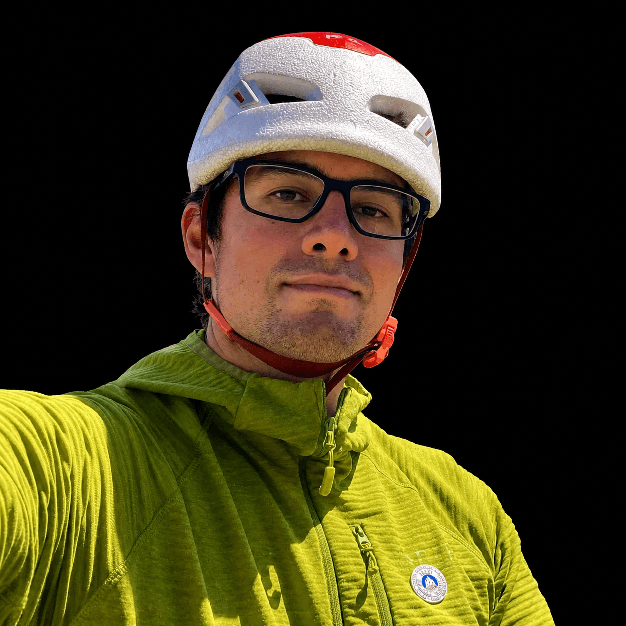 Skyward Mountaineering guide, Buster Jesik is wearing a white helmet and yellow fleece jacket.