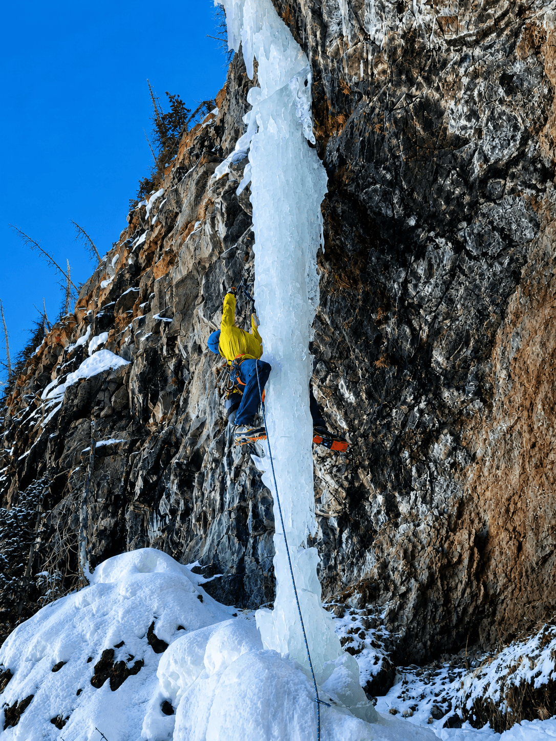 A guide leads a narrow pillar of ice on a backcountry route in the San Juan Mountains.