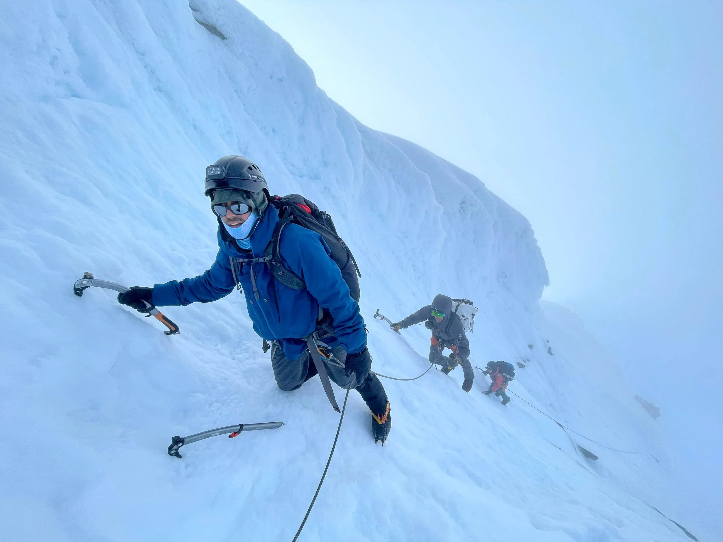 Climbing a snowy summit pyramid on Mt. Shuksan.