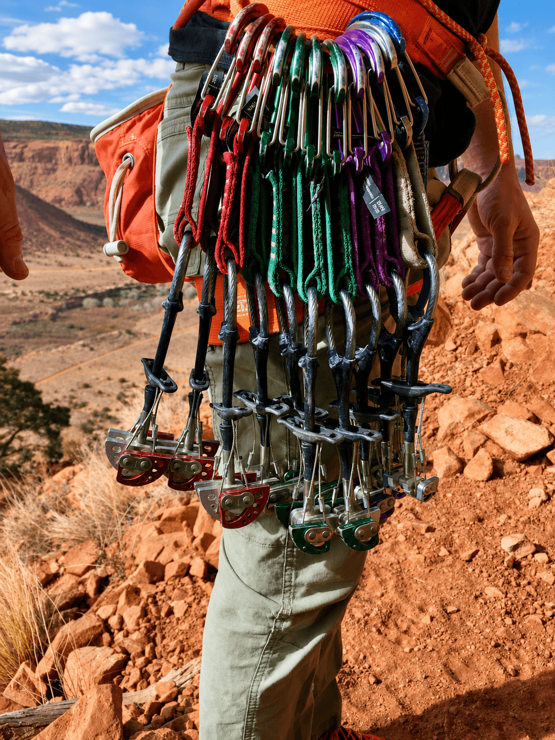 A guide's rock climbing rack with Black Diamond cams on his harness before climbing a route in Escalante Canyon during a crack climbing course.