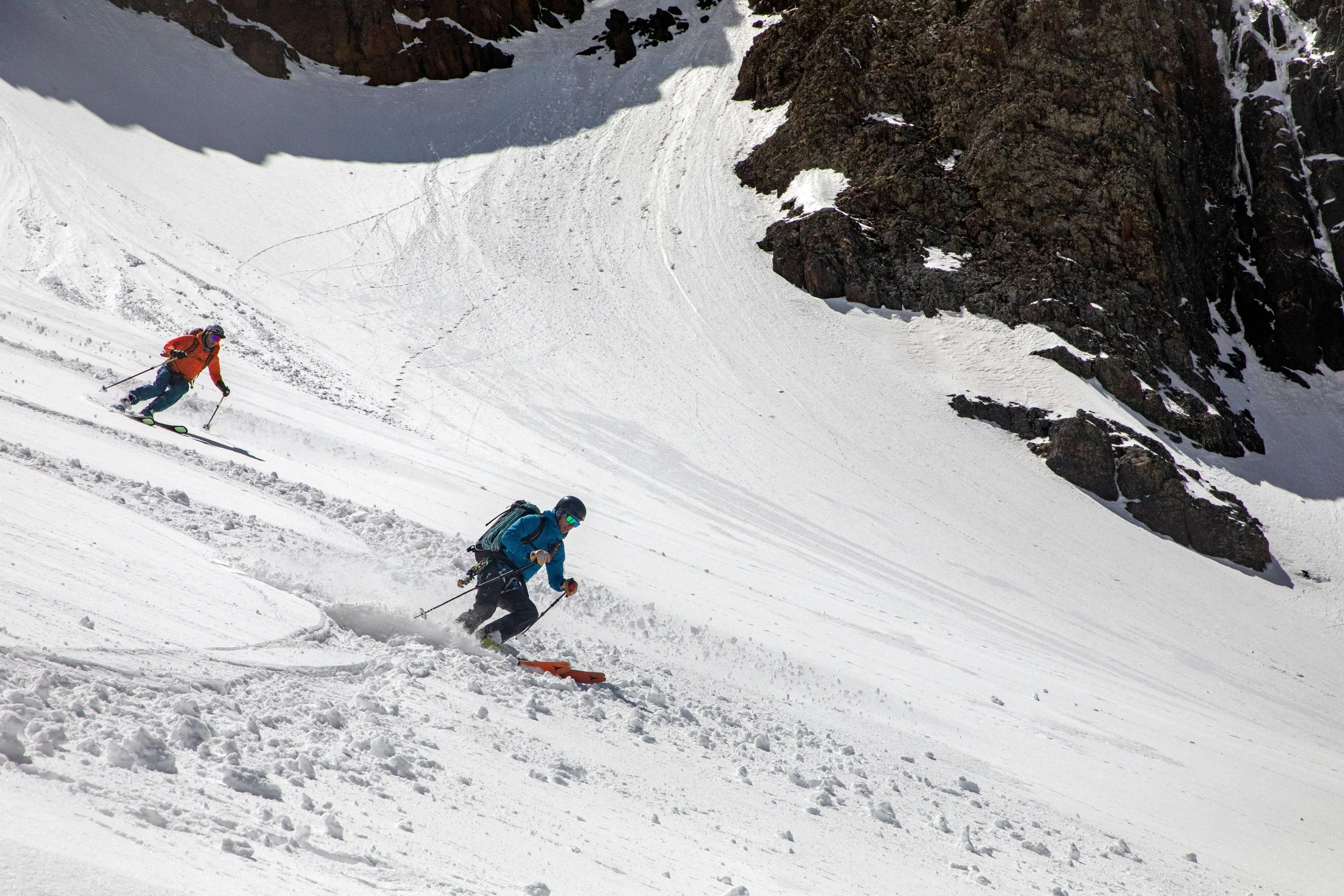 Two skiers descend a steep snow slope on Mount Sneffels.