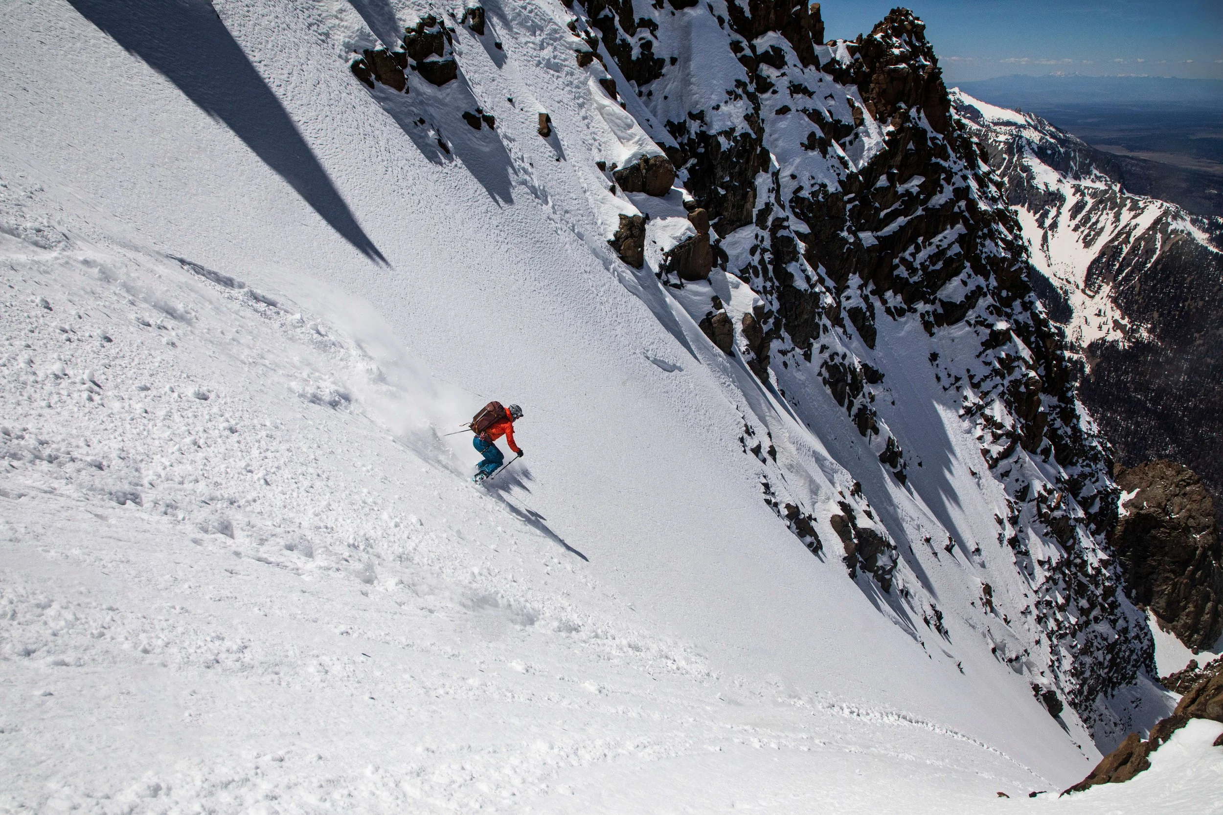 A skier jump turns in a steep couloir in the San Juan Mountains.