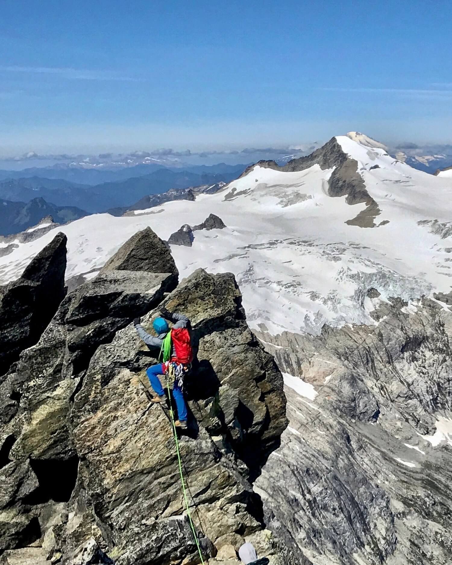 A guide leading up the summit block on the West Ridge of Forbidden Peak.