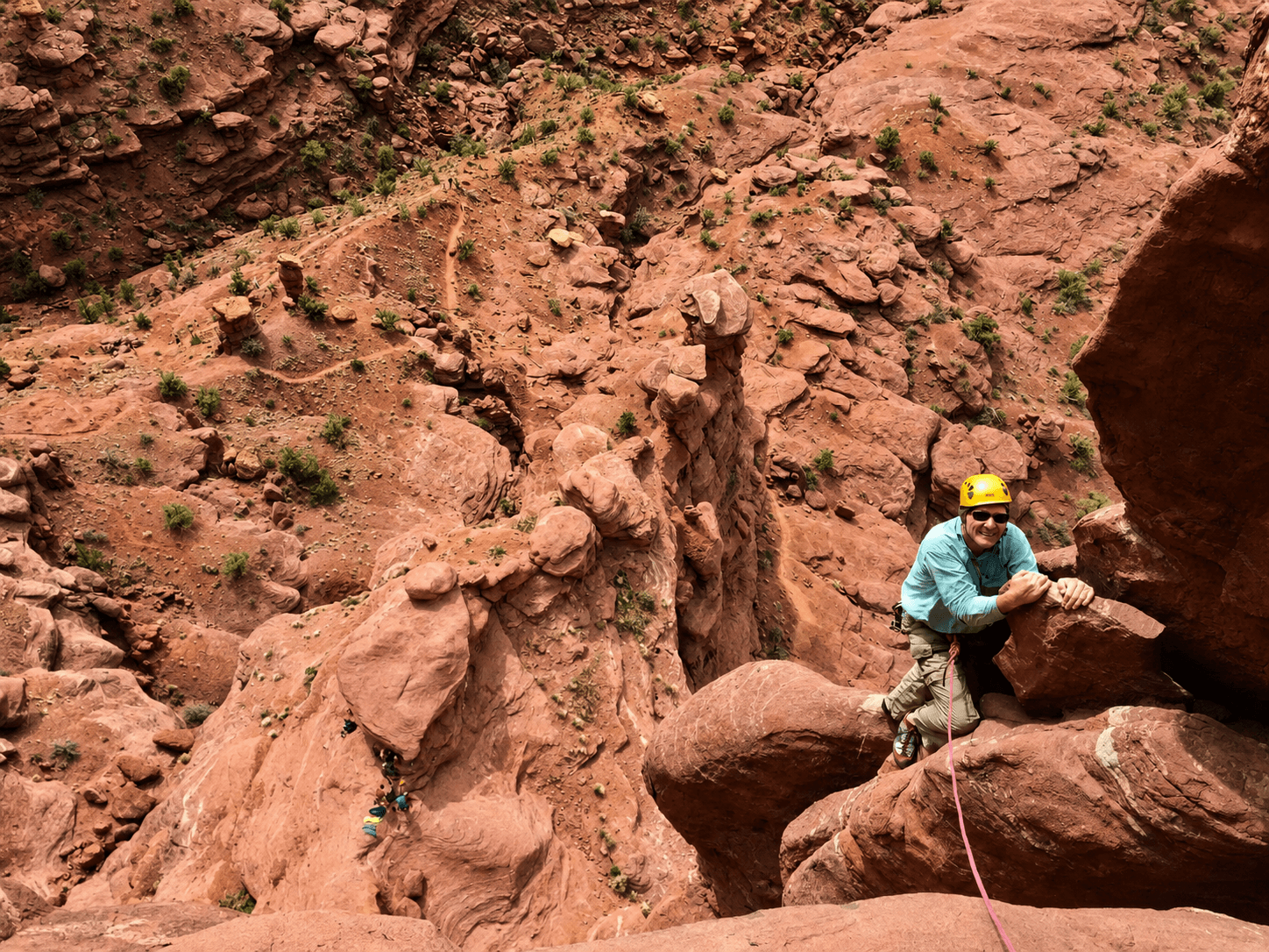 A climber is reaching for the next hold on pitch two of Ancient Art in Moab's Fisher Towers.