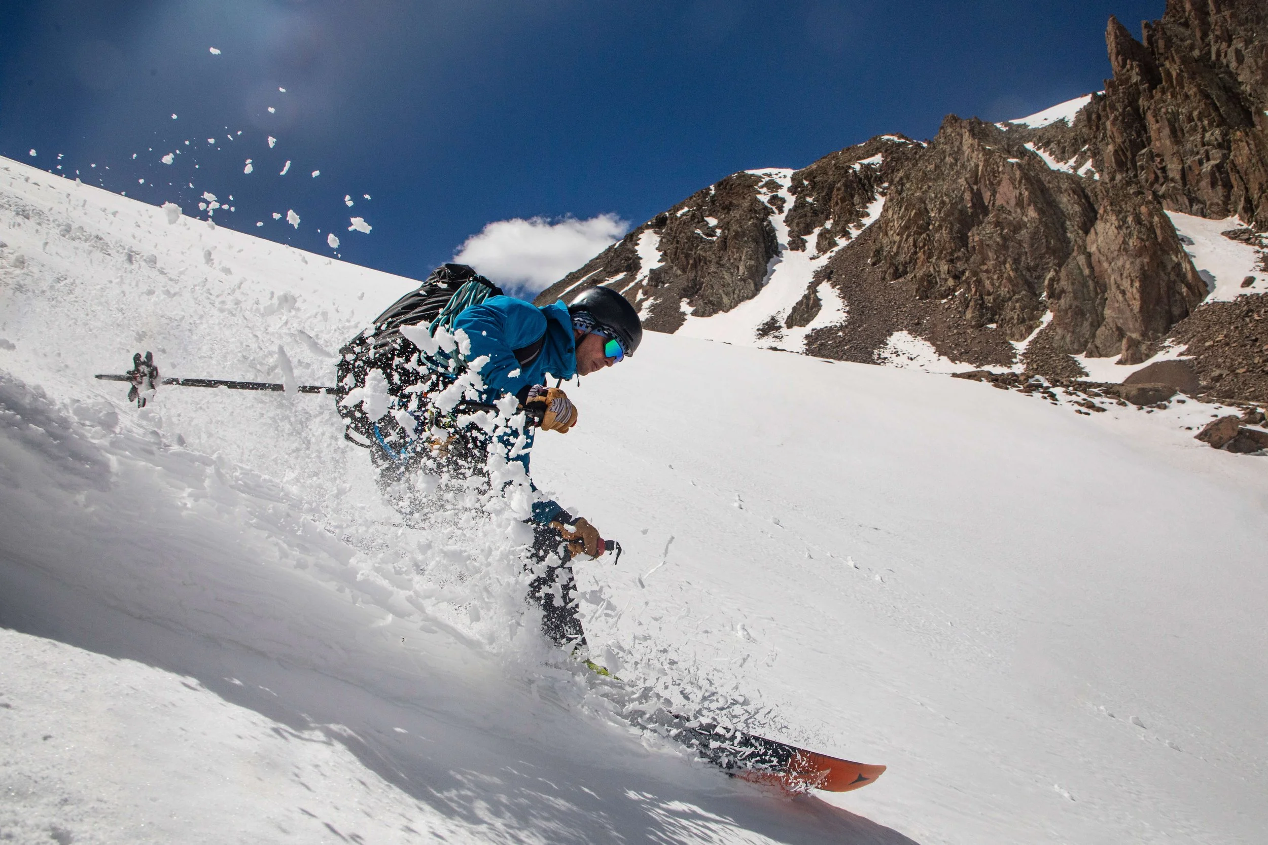 A skier carves a turn in powder on a steep slope in the Ouray backcountry.