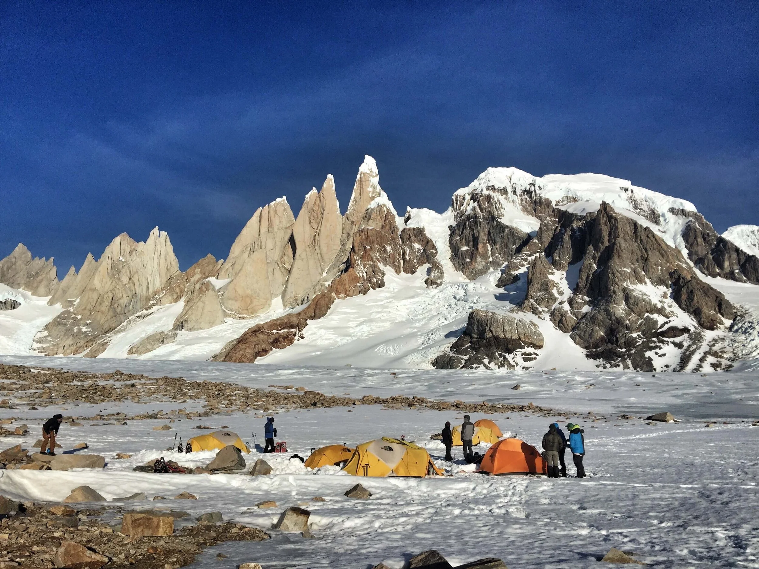 A group of skiers set up basecamp on a glacier below the towers of Patagonia.