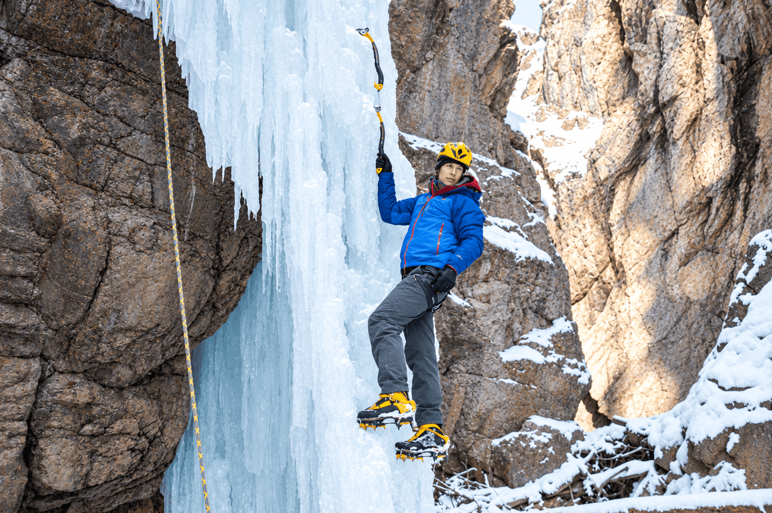 Steve House instructs a Learn To Lead Ice Climbing Course in the Ouray Ice Park. He is wearing a blue jacket and yellow helmet.